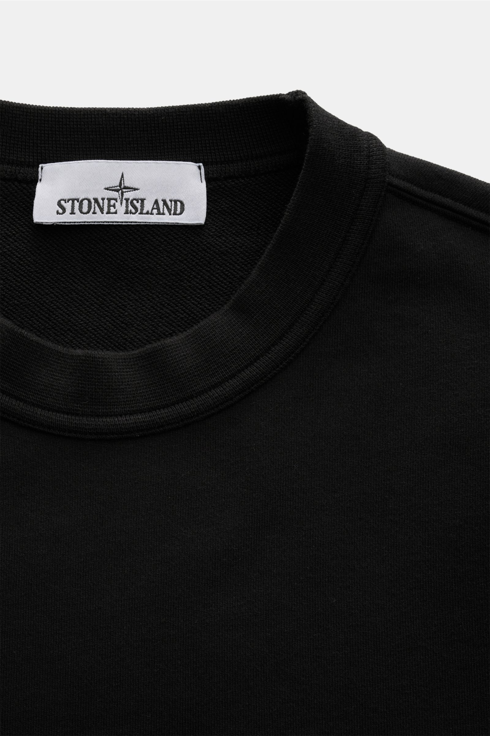 Close-up front view of the black Stone Island Rundhals-Sweatshirt 'Seasonal Pocket' schwarz showing the round neckline and label.

Zeitloses Basic Piece: Das sportive Sweatshirt von STONE ISLAND wird zur idealen Grundlage legerer Freizeitlooks und avan