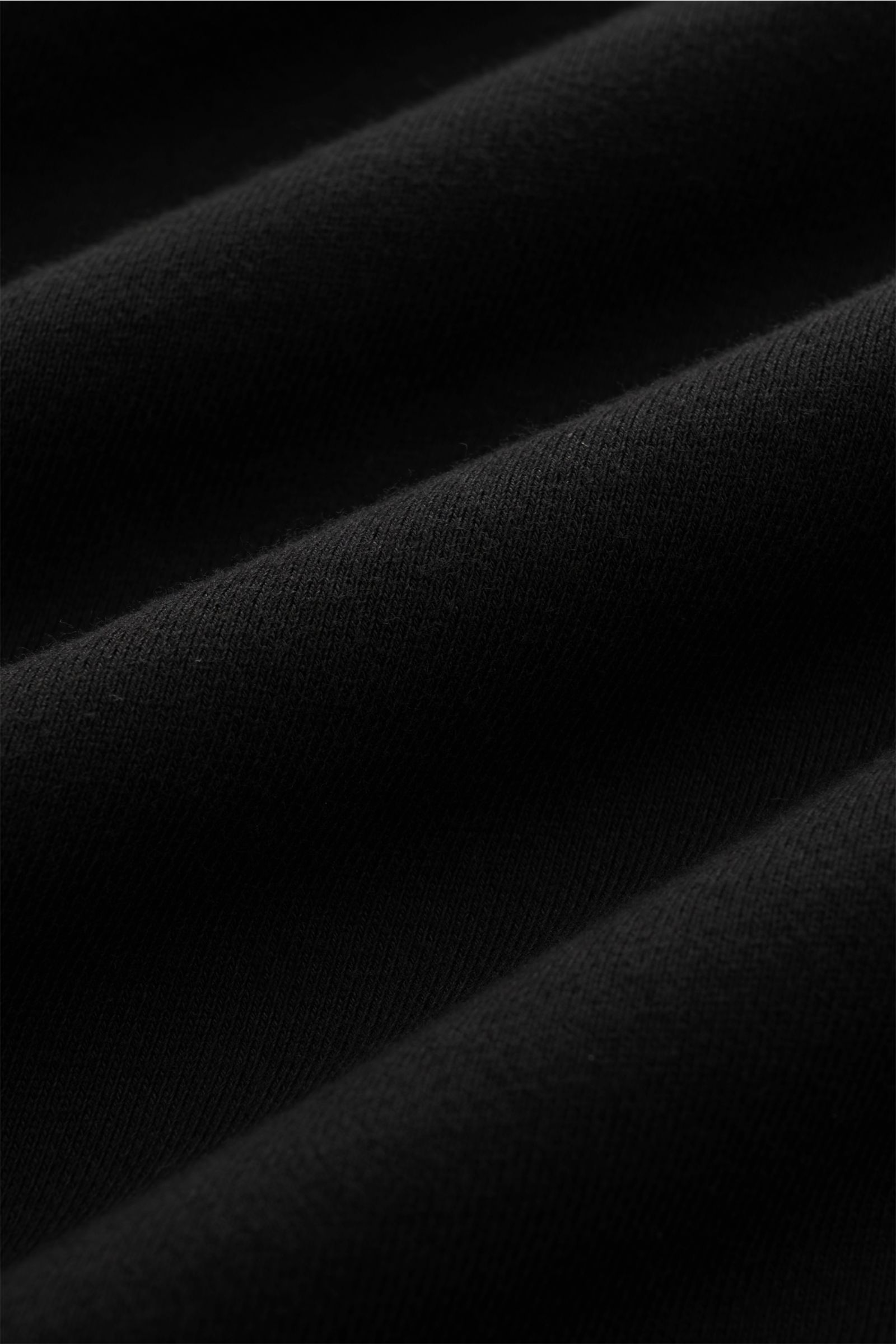 Close-up view of black fabric texture showing the soft cotton material of the Stone Island Rundhals-Sweatshirt 'Seasonal Pocket' schwarz.

Zeitloses Basic Piece: Das sportive Sweatshirt von STONE ISLAND wird zur idealen Grundlage legerer Freizeitlooks 