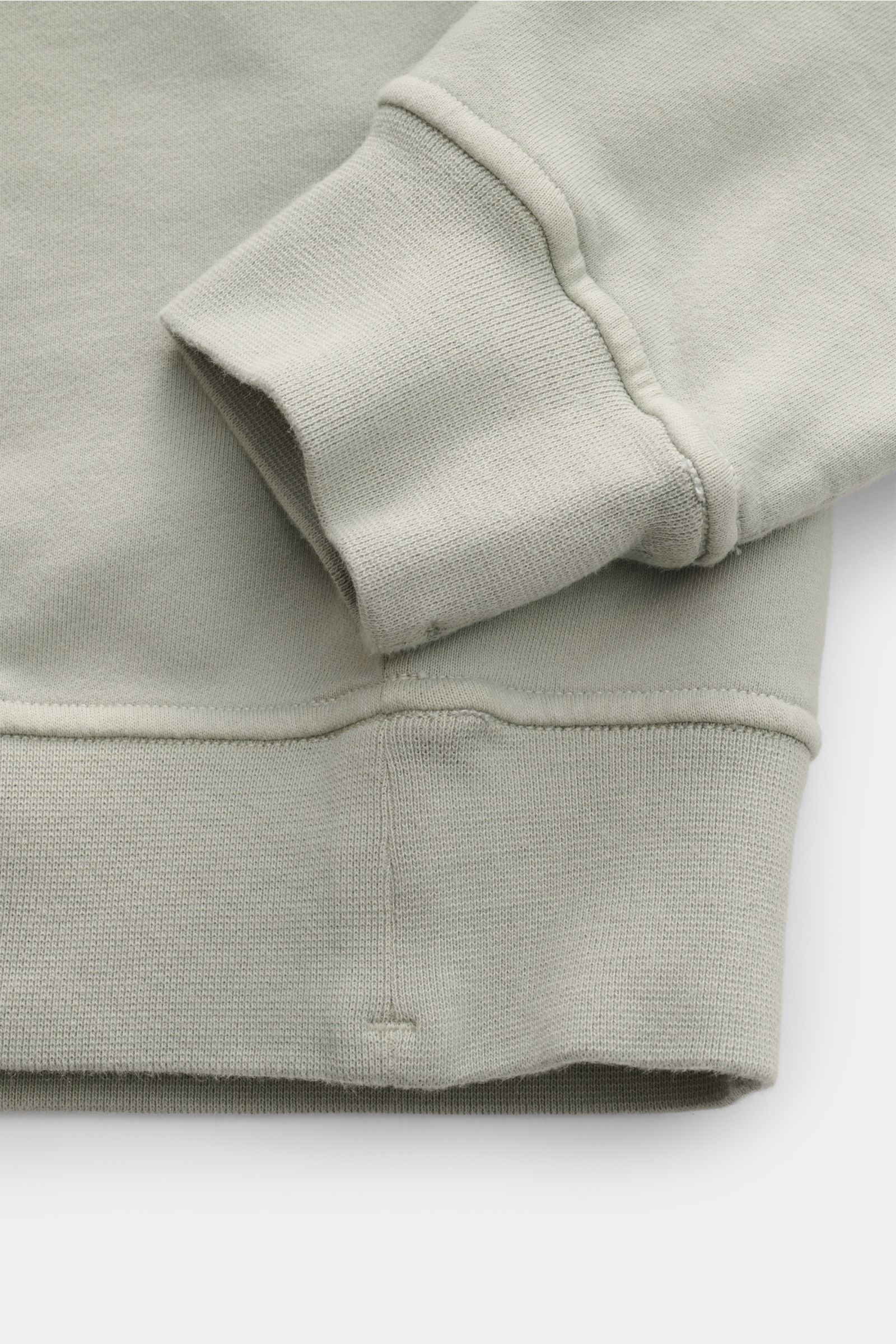 Nahaufnahme von Stone Island Rundhals-Sweatshirt 'Seasonal Pocket' salbei, Detailansicht von Ärmelbündchen und Saum aus reiner Baumwolle, Regular Fit, weicher Griff, mit Kompass-Badge-Tasche am Oberarm und komfortablen Rippbündchen, zeitloses Basic Piece 
