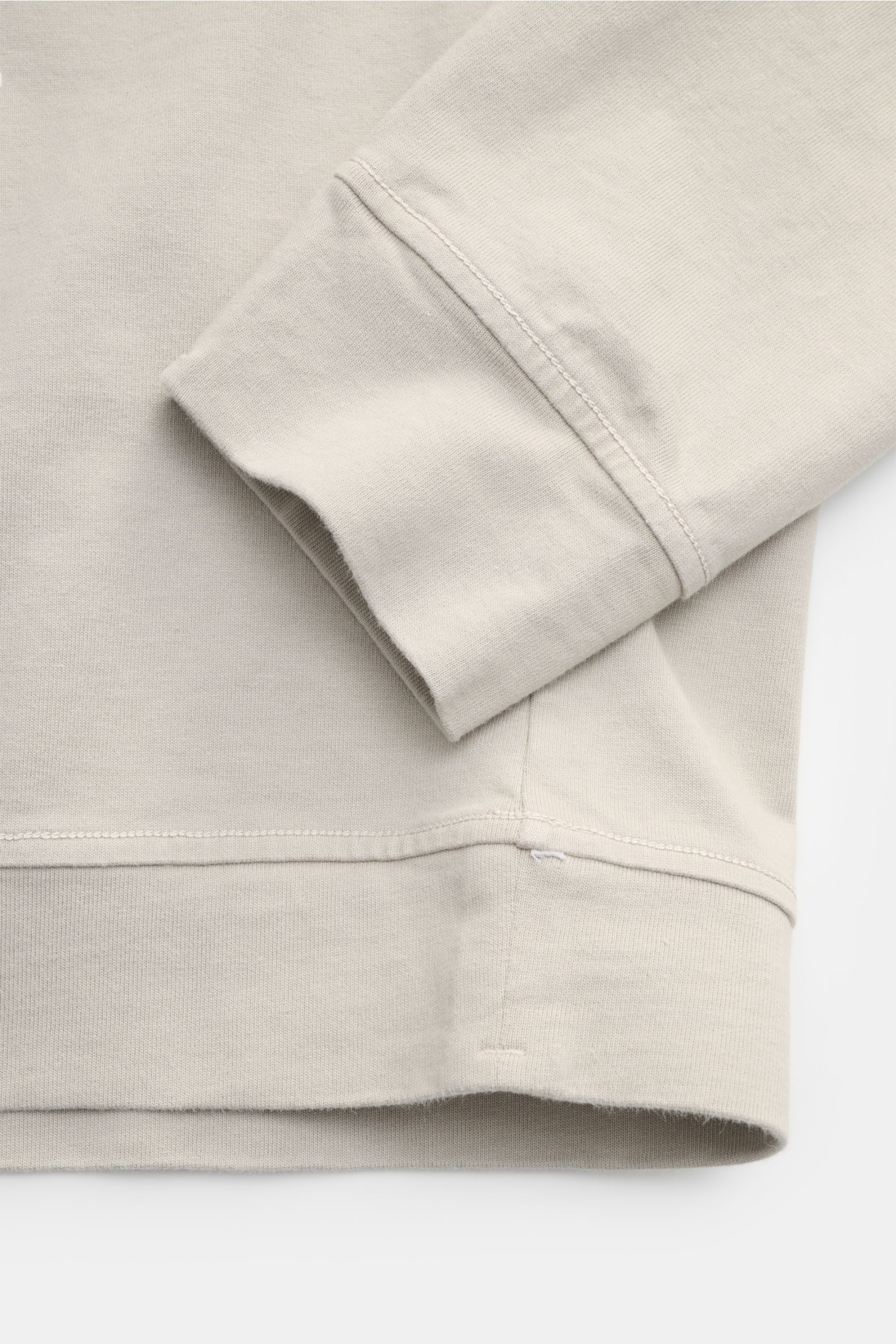 Stone Island Longsleeve hellgrau aus schwerem Baumwolljersey, Rundhalsausschnitt, Kompass-Badge am Ärmel, Detailaufnahme von Ärmel und Saum.