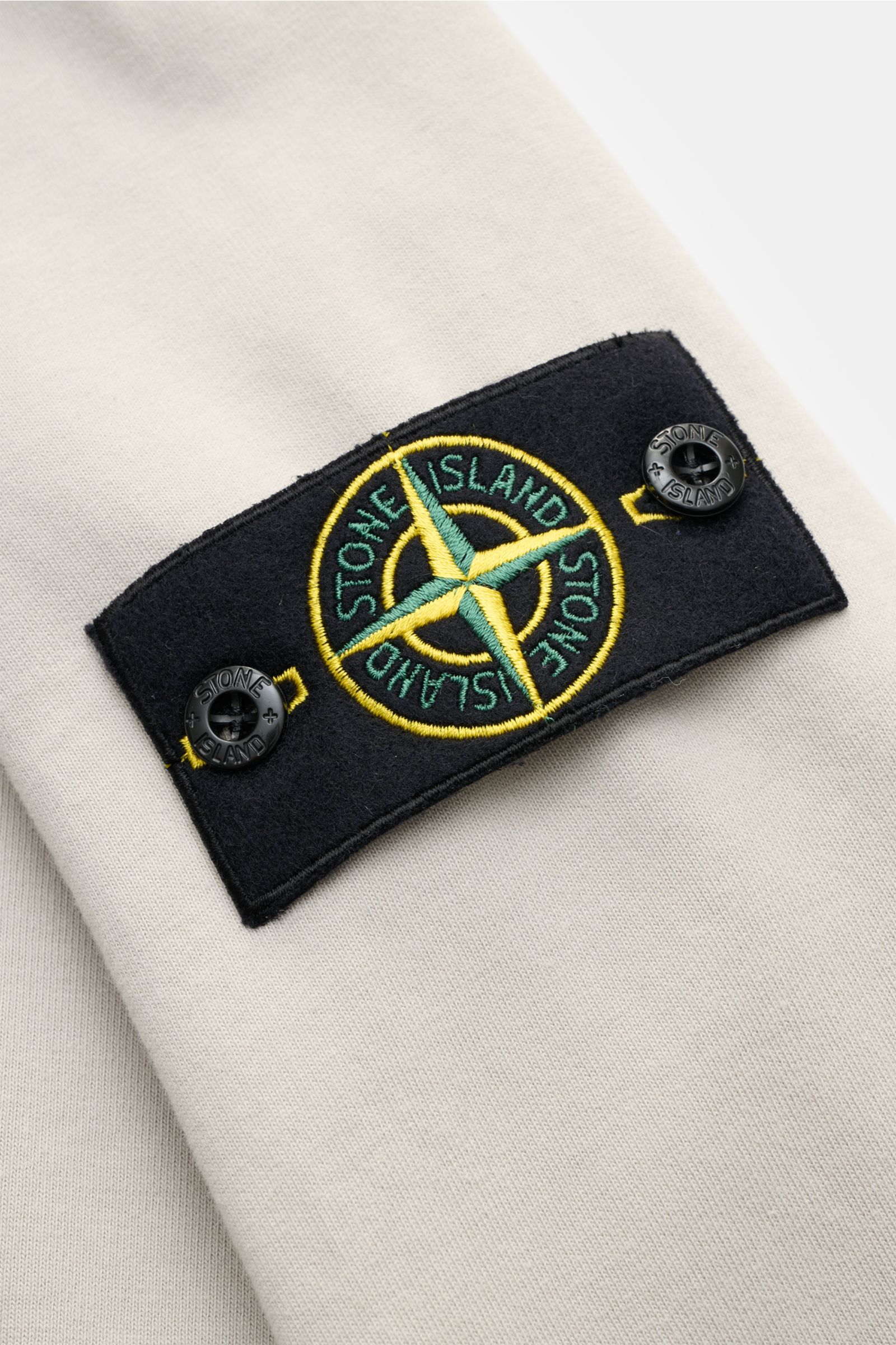Stone Island Longsleeve hellgrau, Detailaufnahme des Kompass-Badges auf dem Ärmel aus Baumwolljersey mit weichem Griff.