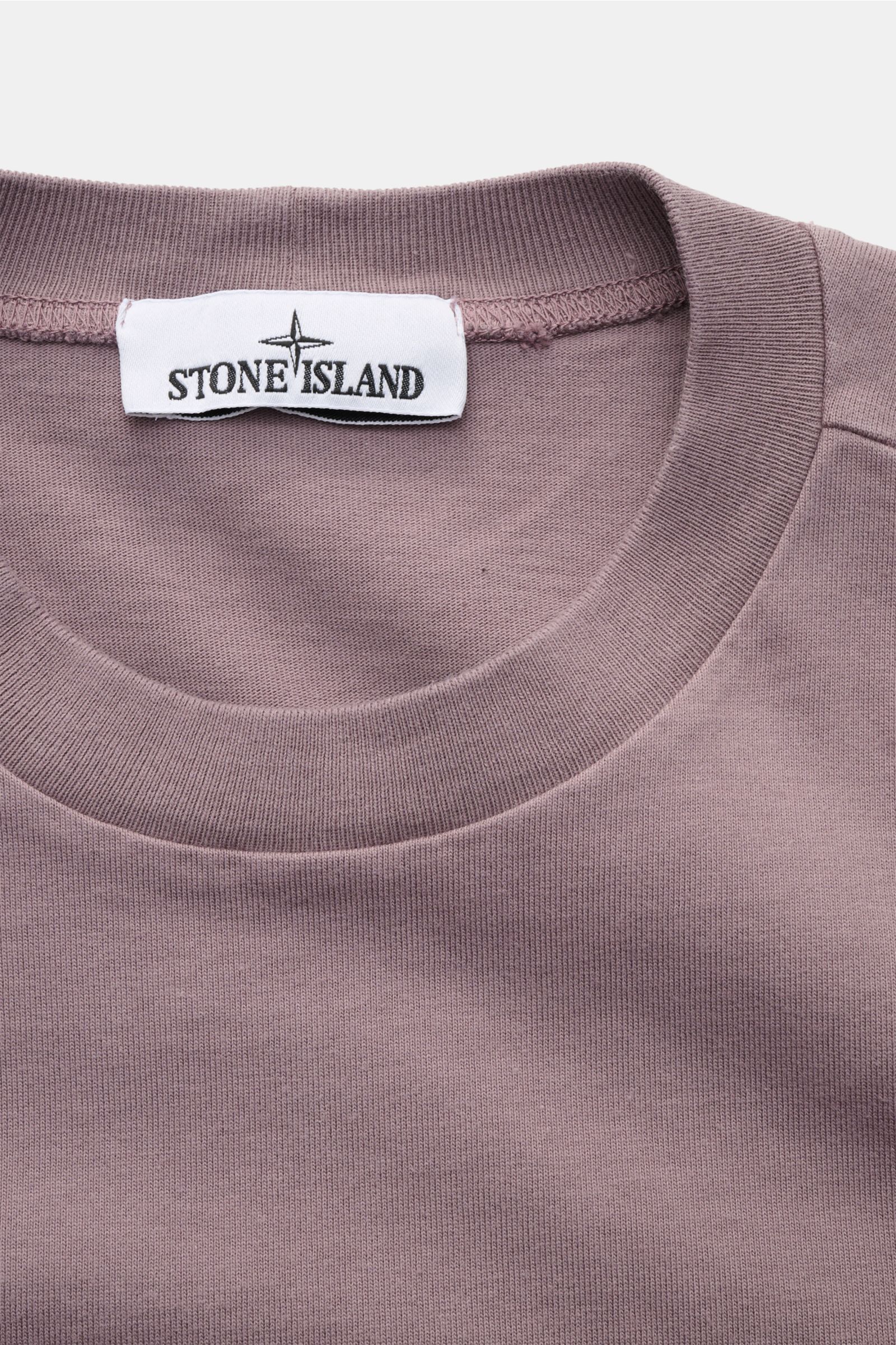 Close-up front view of Stone Island Long sleeve mauve crew neck sweatshirt showing ribbed bands and label.

With this crew neck long sleeve in heavy cotton jersey with compass badge on the sleeve, STONE ISLAND brings us a comfortable basic for cool cas