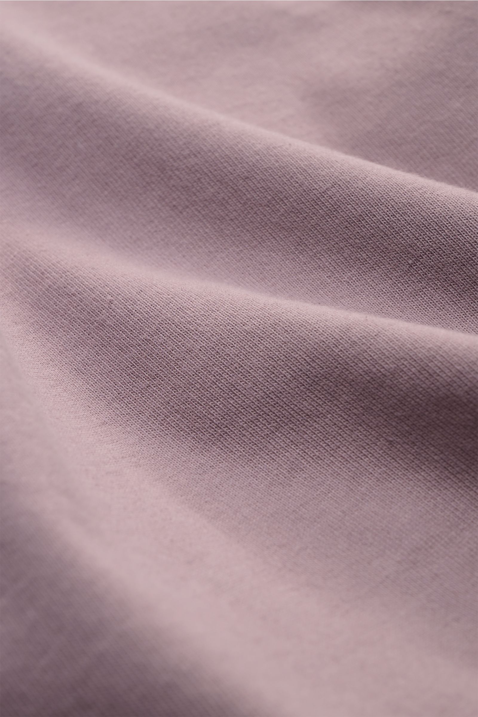 Close-up front view of Stone Island Long sleeve mauve fabric showing heavy cotton jersey texture and soft feel. With this crew neck long sleeve in heavy cotton jersey with compass badge on the sleeve, STONE ISLAND brings us a comfortable basic for cool ca