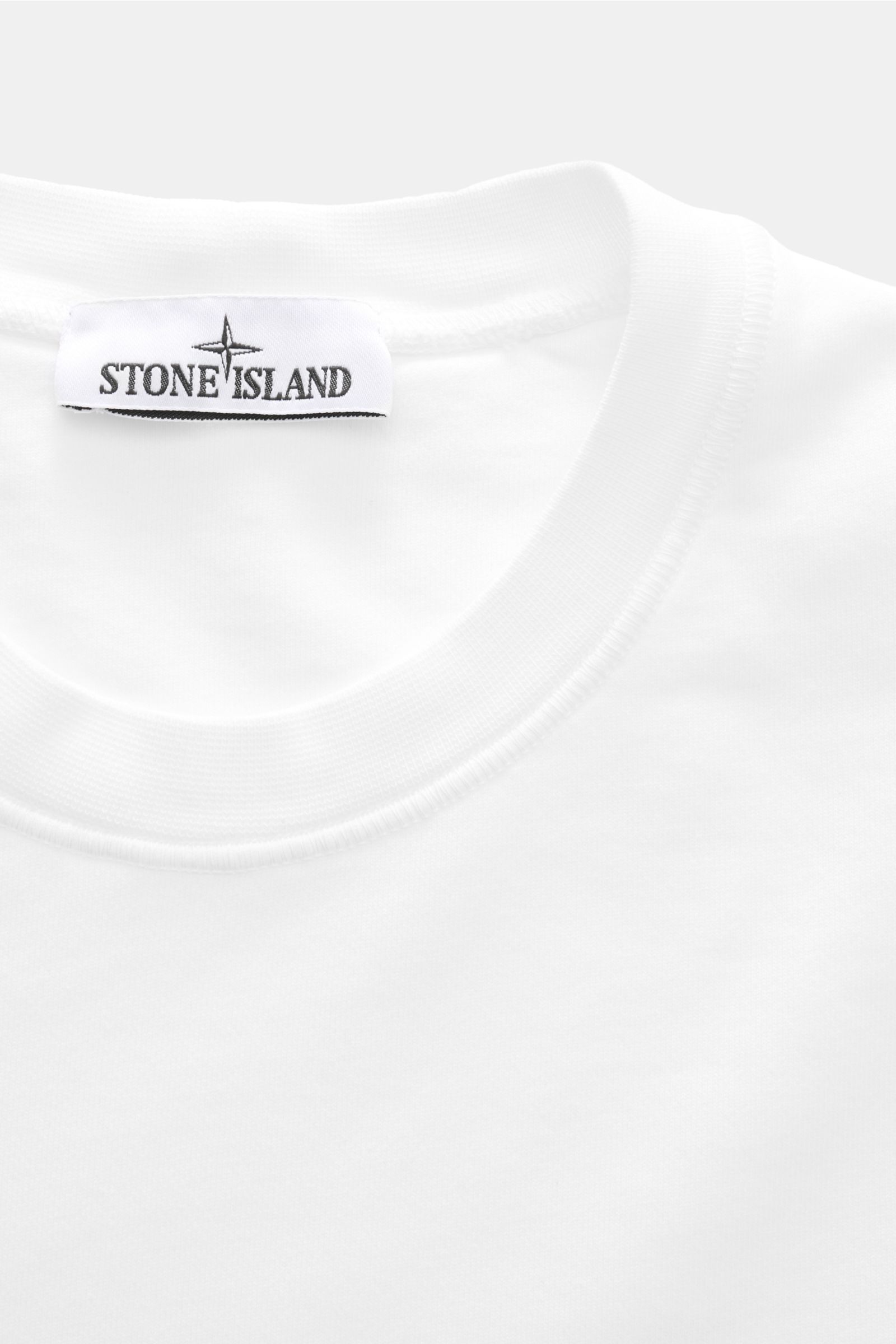 Close-up front view of Stone Island Rundhals-Sweatshirt 'Basic Sweat' weiß showing white cotton fabric and brand label on collar.

Description: Zeitloses Basic Piece: Das sportive Sweatshirt von STONE ISLAND wird zur idealen Grundlage legerer Freizeitl