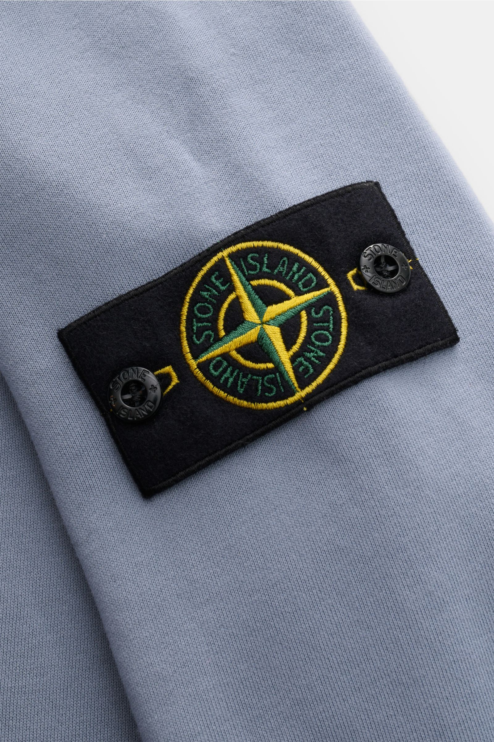 Stone Island Rundhals-Sweatshirt 'Basic Sweat' rauchblau, Nahaufnahme des Kompass-Badges am Oberarm aus reiner Baumwolle, weicher Griff.