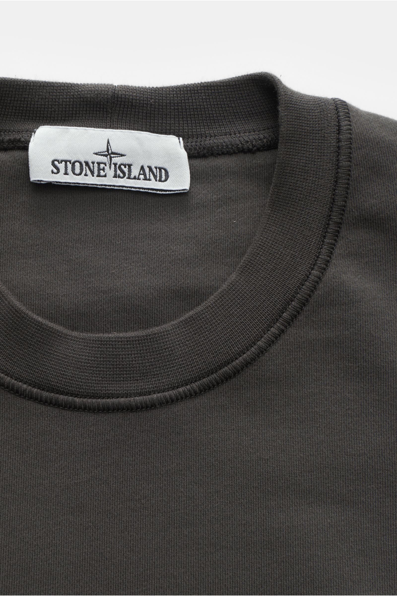 Stone Island Rundhals-Sweatshirt 'Basic Sweat' dunkelgrau shown close-up from above, highlighting the ribbed crew neck and fabric texture. 

Zeitloses Basic Piece: Das sportive Sweatshirt von STONE ISLAND wird zur idealen Grundlage legerer Freizeitlook