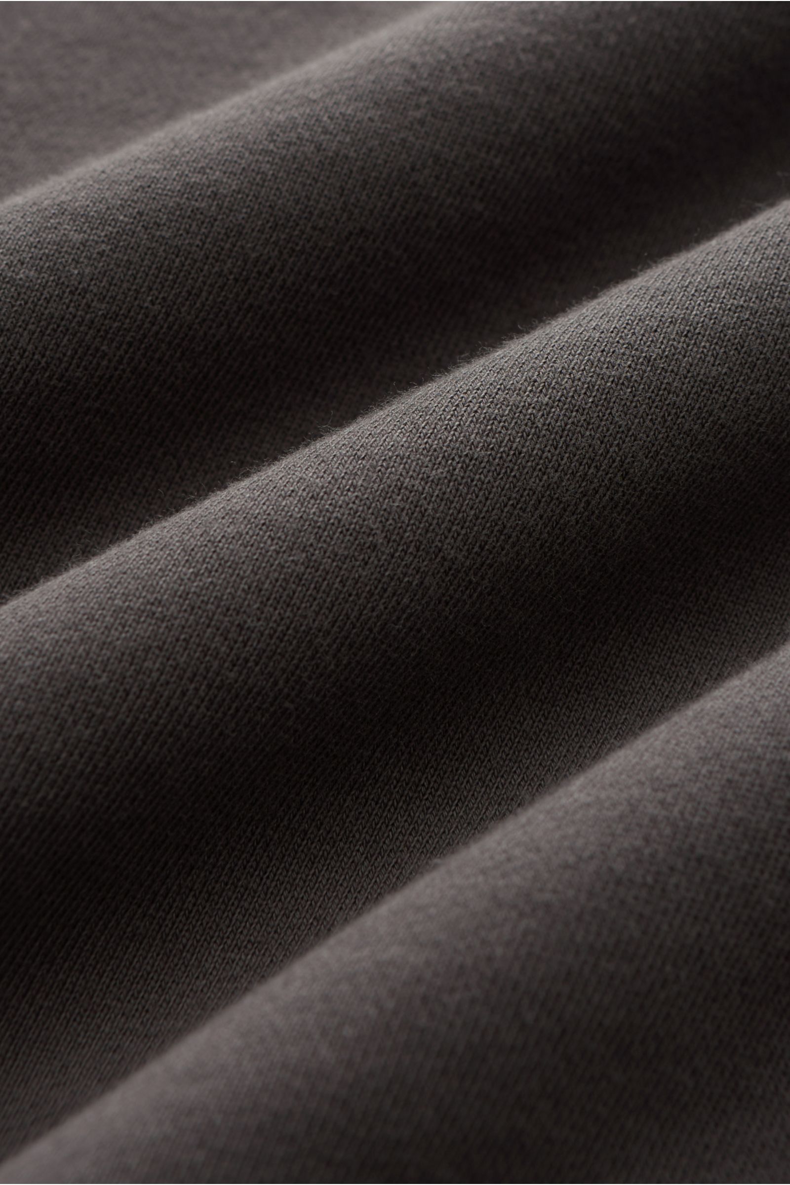 Close-up fabric texture of the Stone Island Rundhals-Sweatshirt 'Basic Sweat' dunkelgrau, showing soft, dark gray cotton material.

Zeitloses Basic Piece: Das sportive Sweatshirt von STONE ISLAND wird zur idealen Grundlage legerer Freizeitlooks und ava
