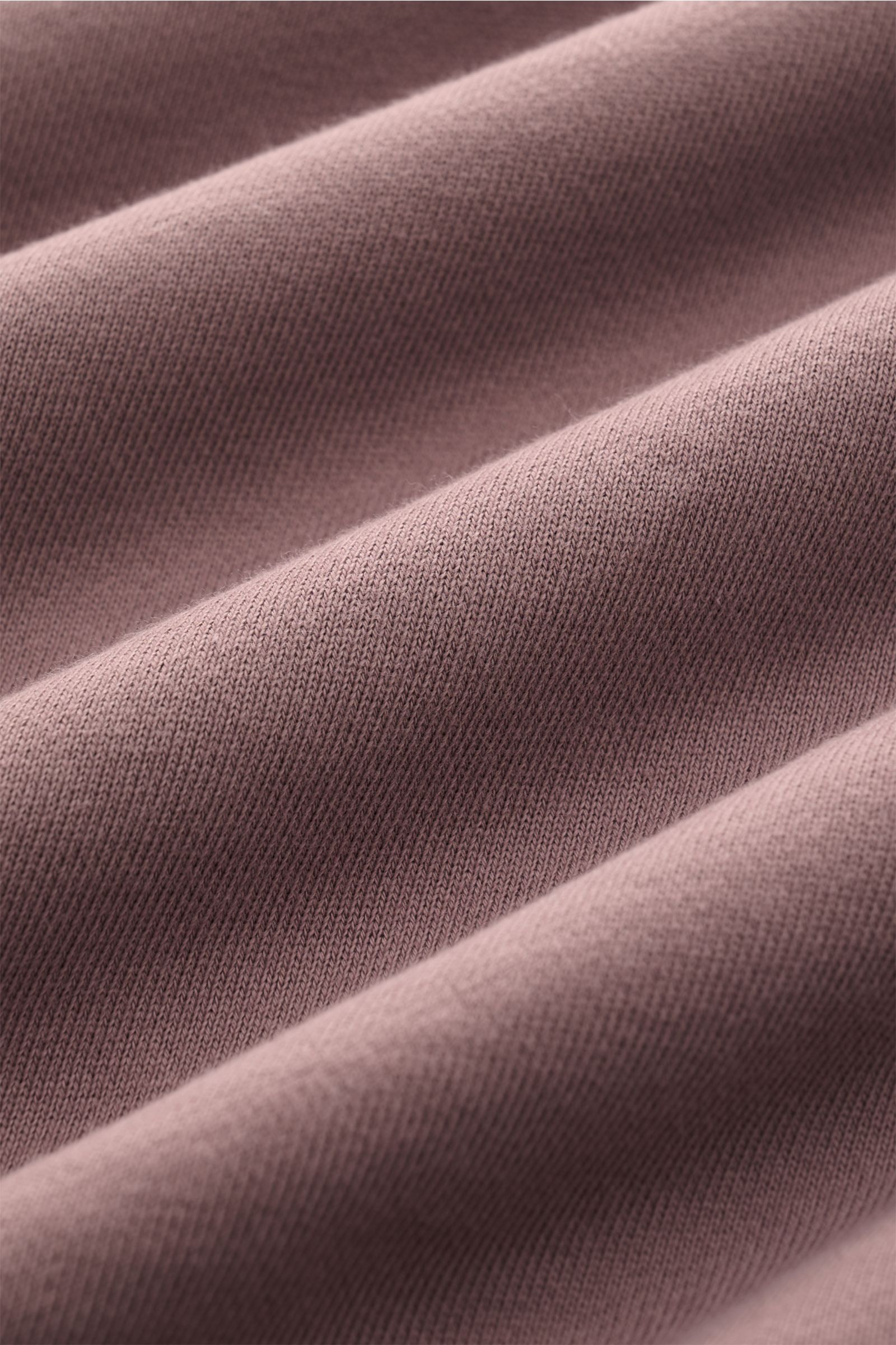 Close-up fabric texture of the Stone Island Rundhals-Sweatshirt 'Basic Sweat' flieder, showing soft lilac cotton knit from a top-angle perspective.

Zeitloses Basic Piece: Das sportive Sweatshirt von STONE ISLAND wird zur idealen Grundlage legerer Frei