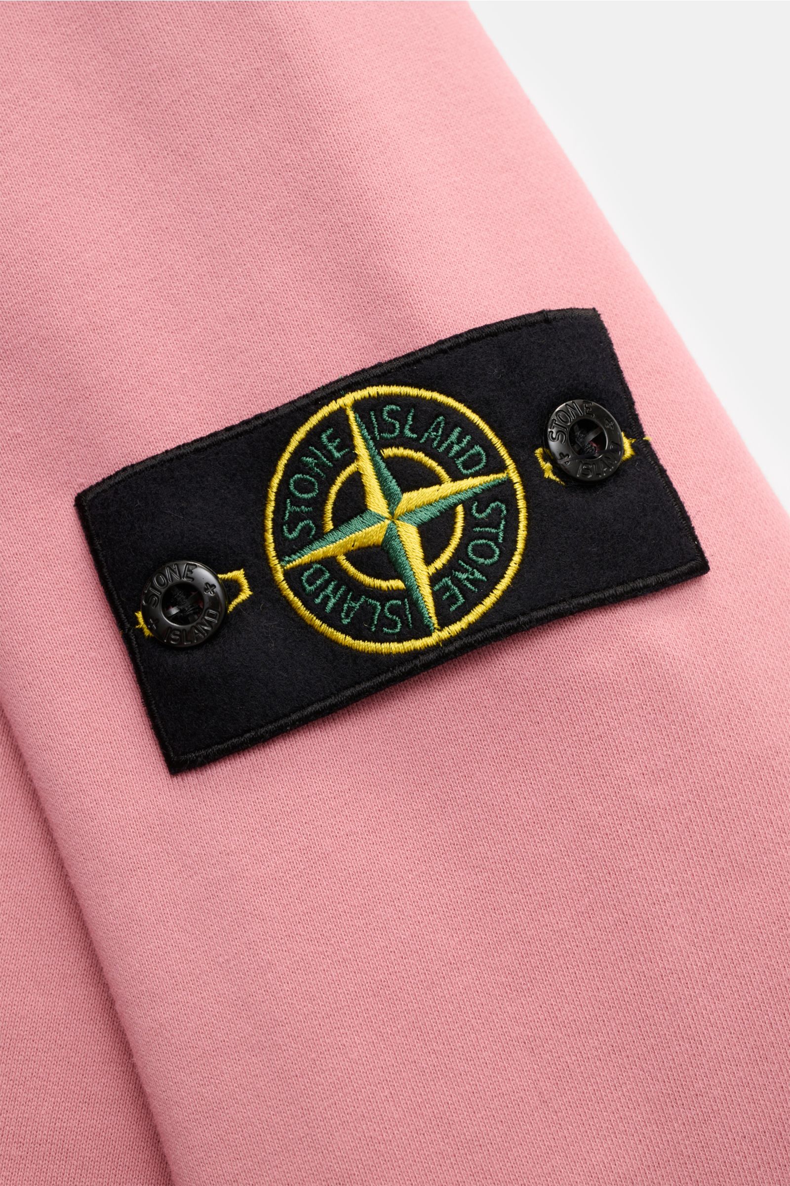 Nahaufnahme des Kompass-Badges am Oberarm des Stone Island Rundhals-Sweatshirt 'Basic Sweat' rosé aus reiner Baumwolle mit weichem Griff und Rippbündchen.