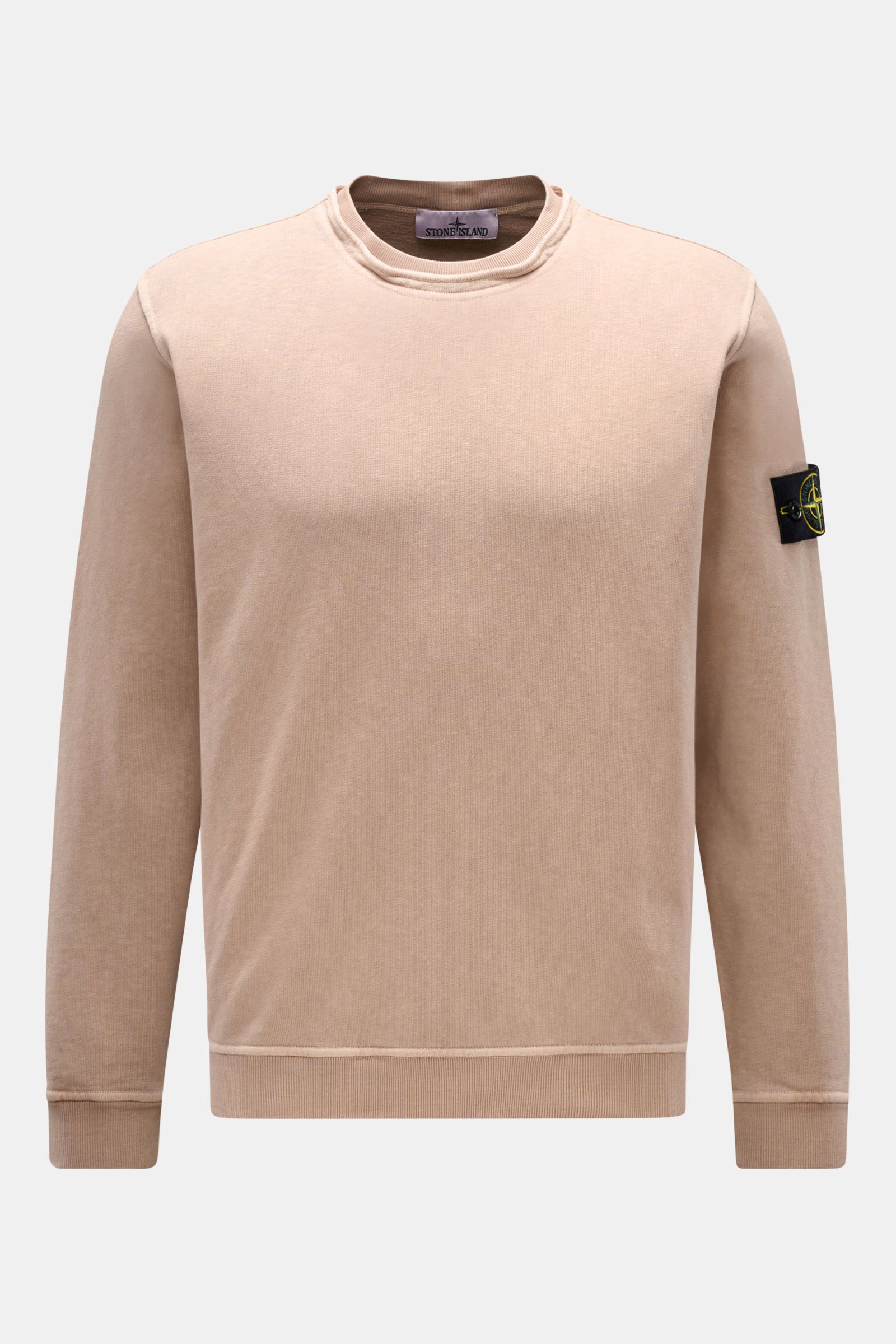 Stone Island Rundhals-Sweatshirt 'Washed Sweat' beige, frontal fotografiert, mit typischer Stückfärbung, modernem Washed-Effekt, außenliegender Nahtkante am Rundhalsausschnitt, Kompass-Badge am Oberarm, Rippbündchen, Regular Fit und weichem Baumwollstoff.