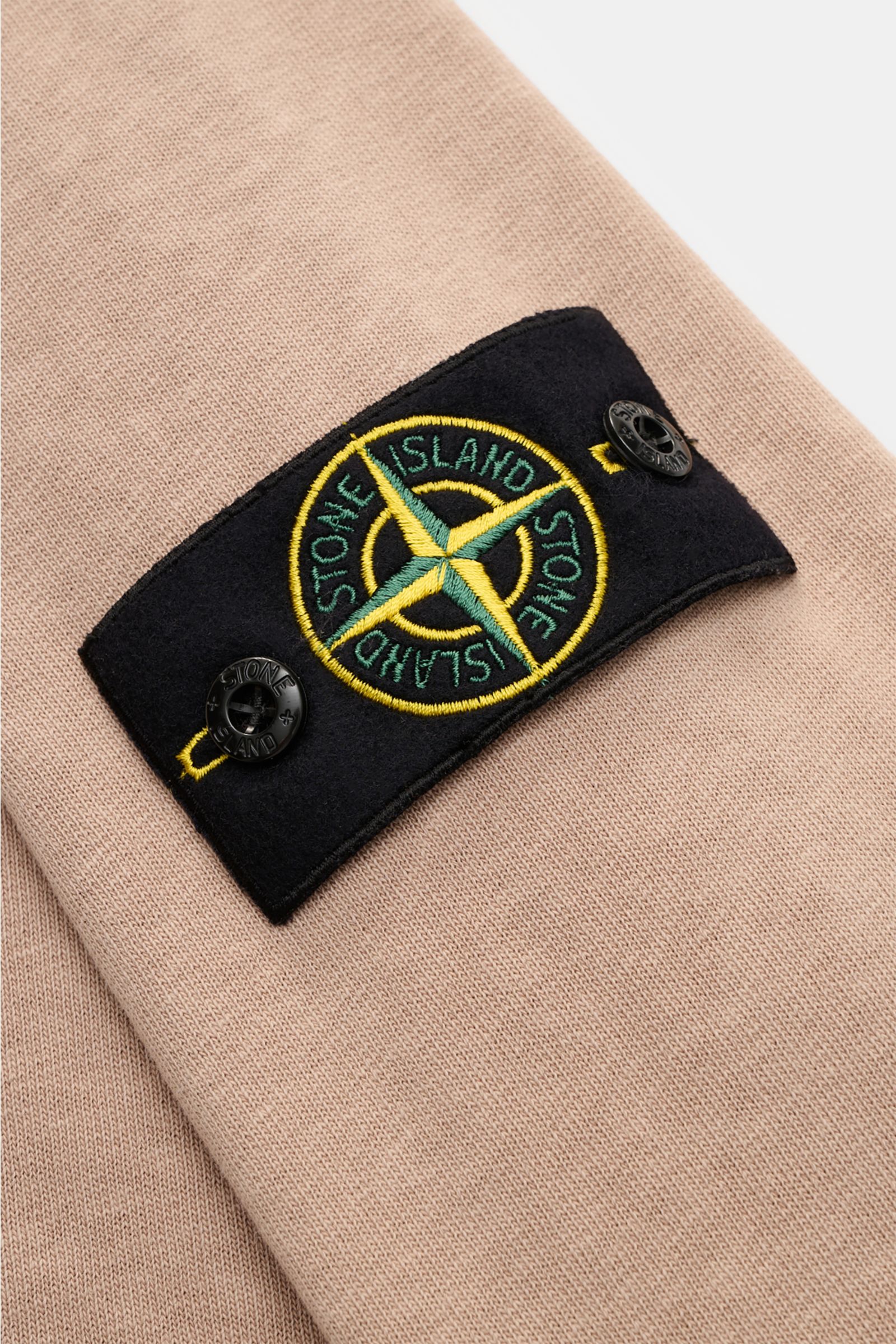 Stone Island Rundhals-Sweatshirt 'Washed Sweat' beige mit Kompass-Badge am Oberarm, Sweat aus Baumwolle mit weichem Griff, Nahaufnahme frontal.
