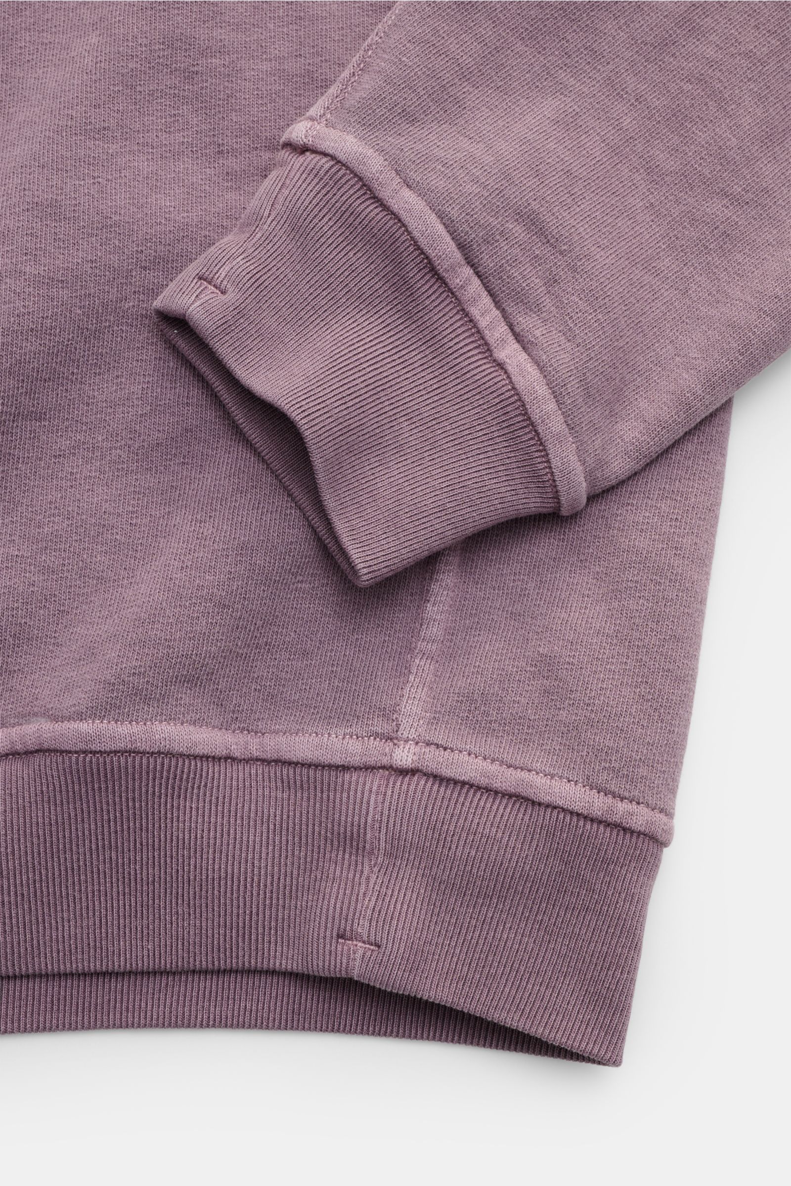 Nahaufnahme des Stone Island Rundhals-Sweatshirts „Washed Sweat“ flieder von oben, mit weichem Baumwollstoff, Washed-Effekt, Nahtkante und Rippbündchen.