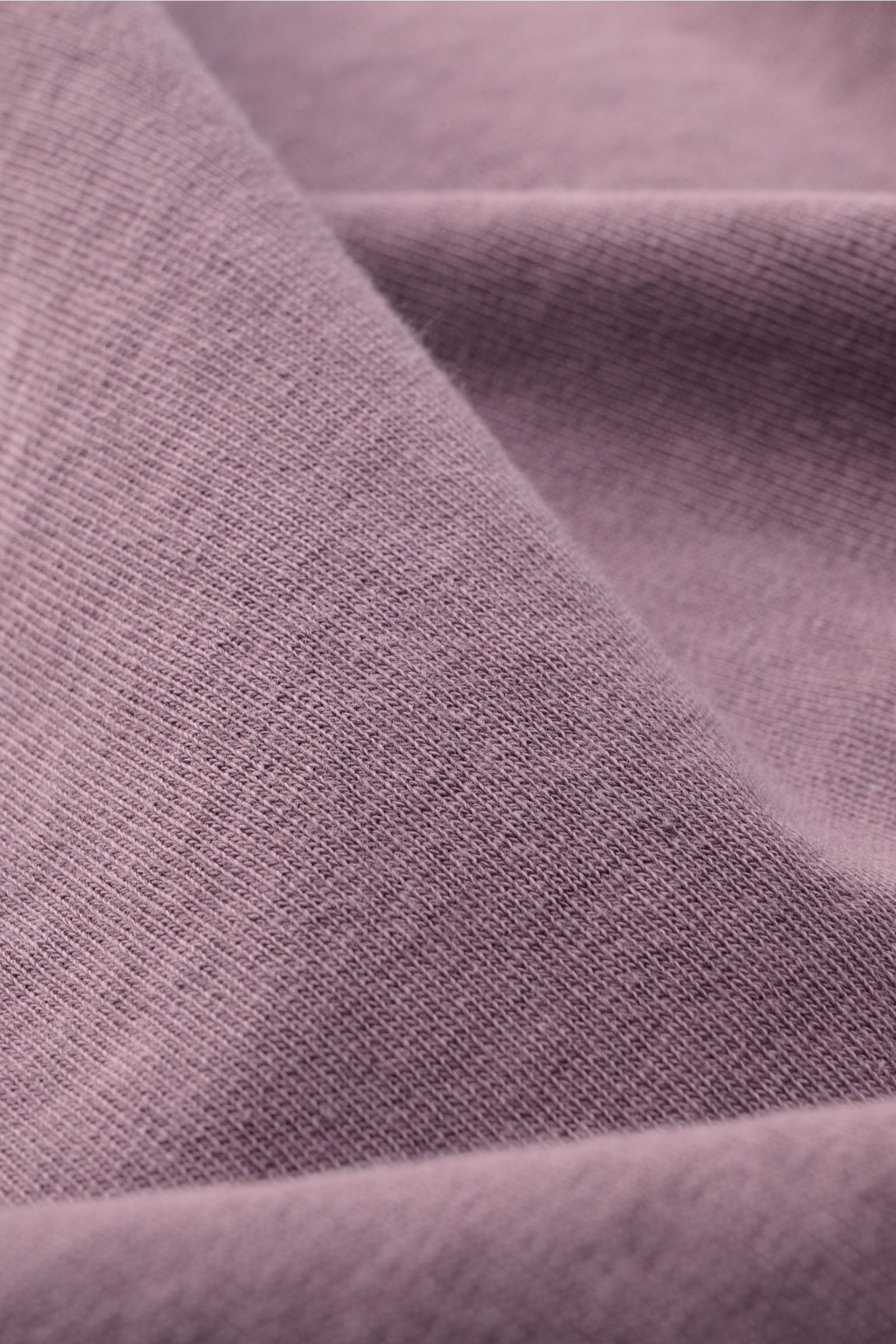 Nahaufnahme des fliederfarbenen Stone Island Rundhals-Sweatshirt 'Washed Sweat' mit weichem Baumwollstoff und authentischem Washed-Effekt.