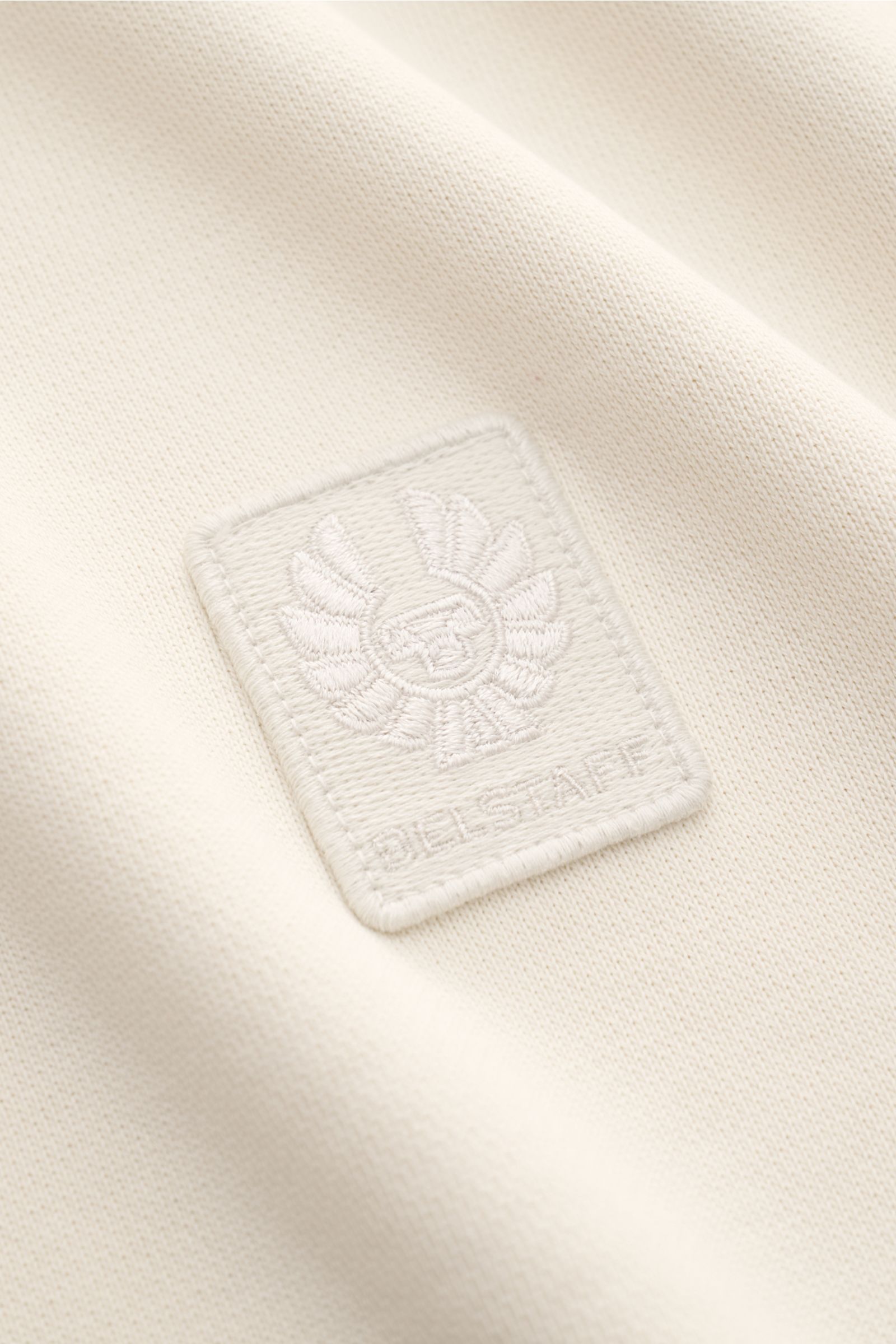 Belstaff Sweatshirt sand aus reiner Baumwolle, Slim Fit, weicher Griff, V-Stitch am Rundhalsausschnitt, tonales Weblabel nah fotografiert.