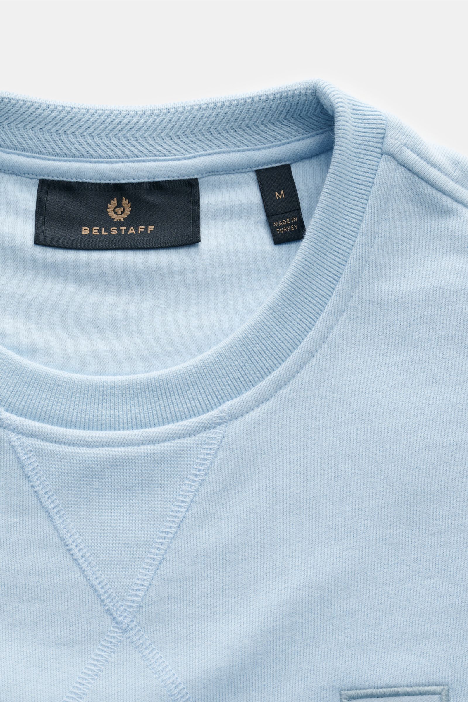 Belstaff Sweatshirt hellblau aus reiner Baumwolle, Slim Fit, weicher Griff, V-Stitch am Rundhalsausschnitt, tonales Weblabel, flexible Rippbündchen, Nahaufnahme von oben.