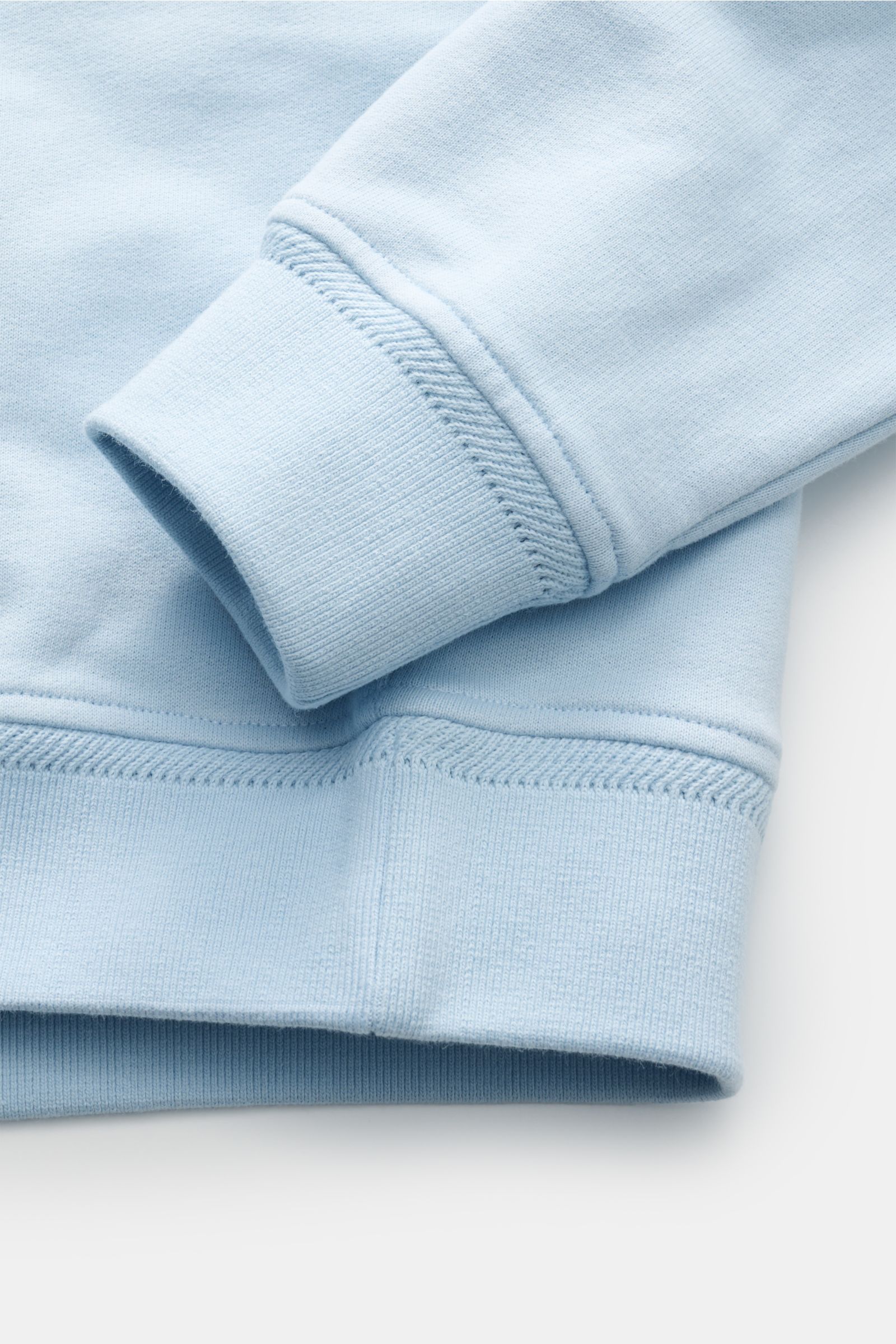 Nahaufnahme des Belstaff Sweatshirt hellblau in Slim Fit, Fokus auf weiche Baumwolle, flexible Rippbündchen und V-Stitch-Details.