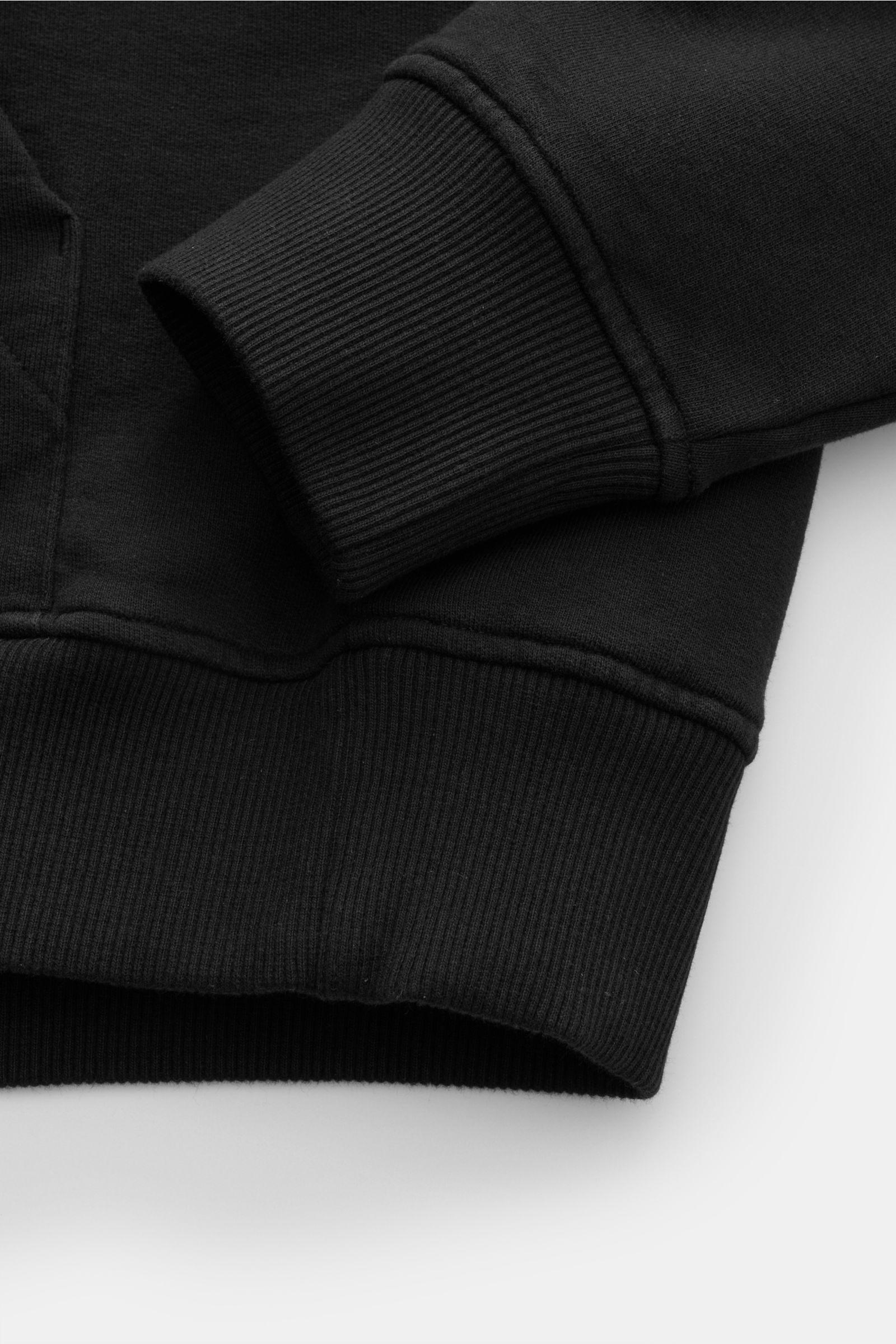 Nahaufnahme des schwarzen Ami Paris Kapuzenpullovers mit Kängurutasche, Kapuze, flexiblem Rippbündchen und Logo-Stitching.