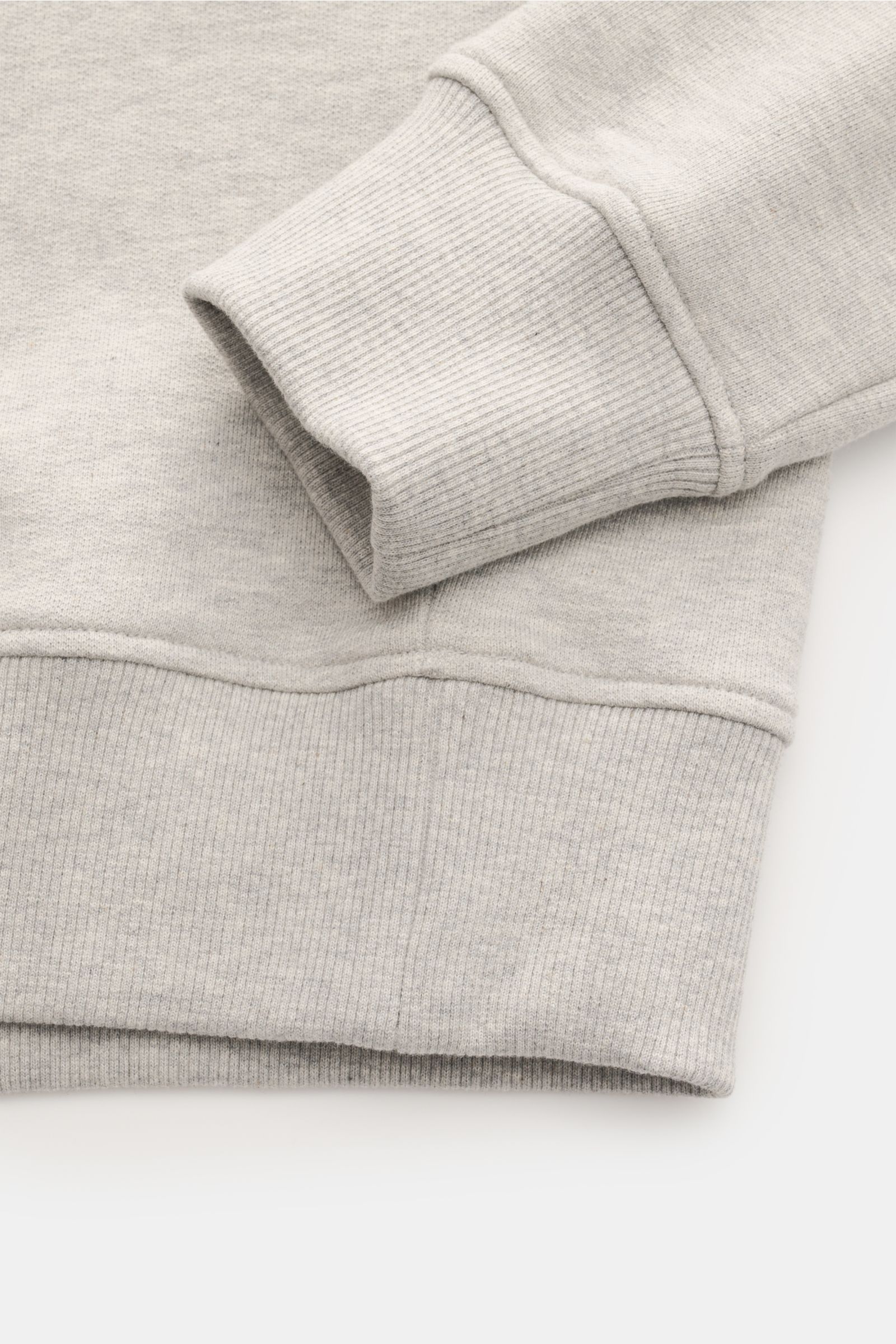 Nahaufnahme des Ärmelbündchens und Saums vom Ami Paris Sweatshirt 'Crewneck' grau meliert aus leicht elastischer Baumwolle, Slim Fit mit markantem Stitching.