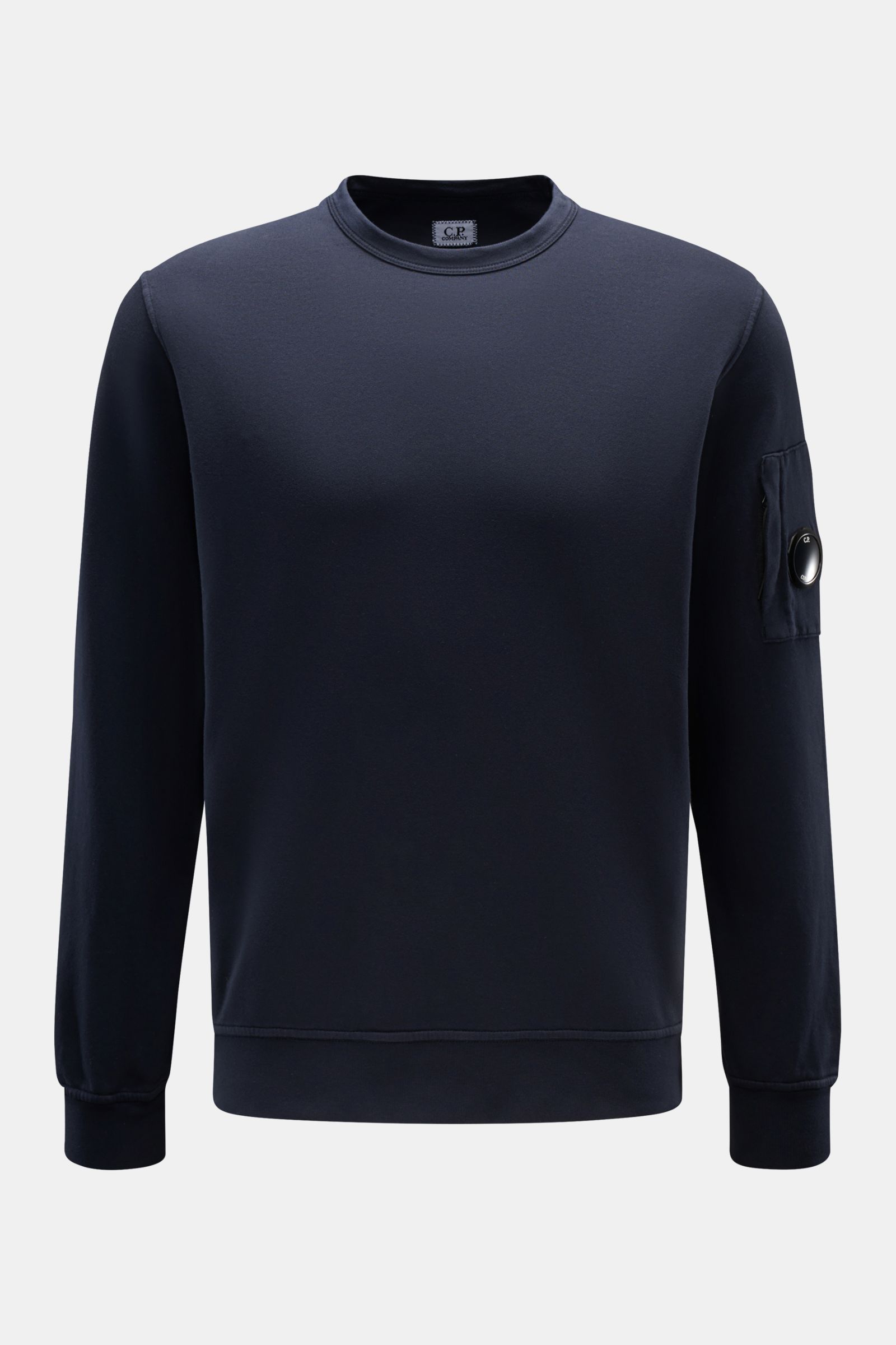 C.P. Company Sweatshirt navy shown front view, slim fit garment dyed cotton with round neck, zipper pocket on left sleeve, lens detail, and ribbed cuffs. 