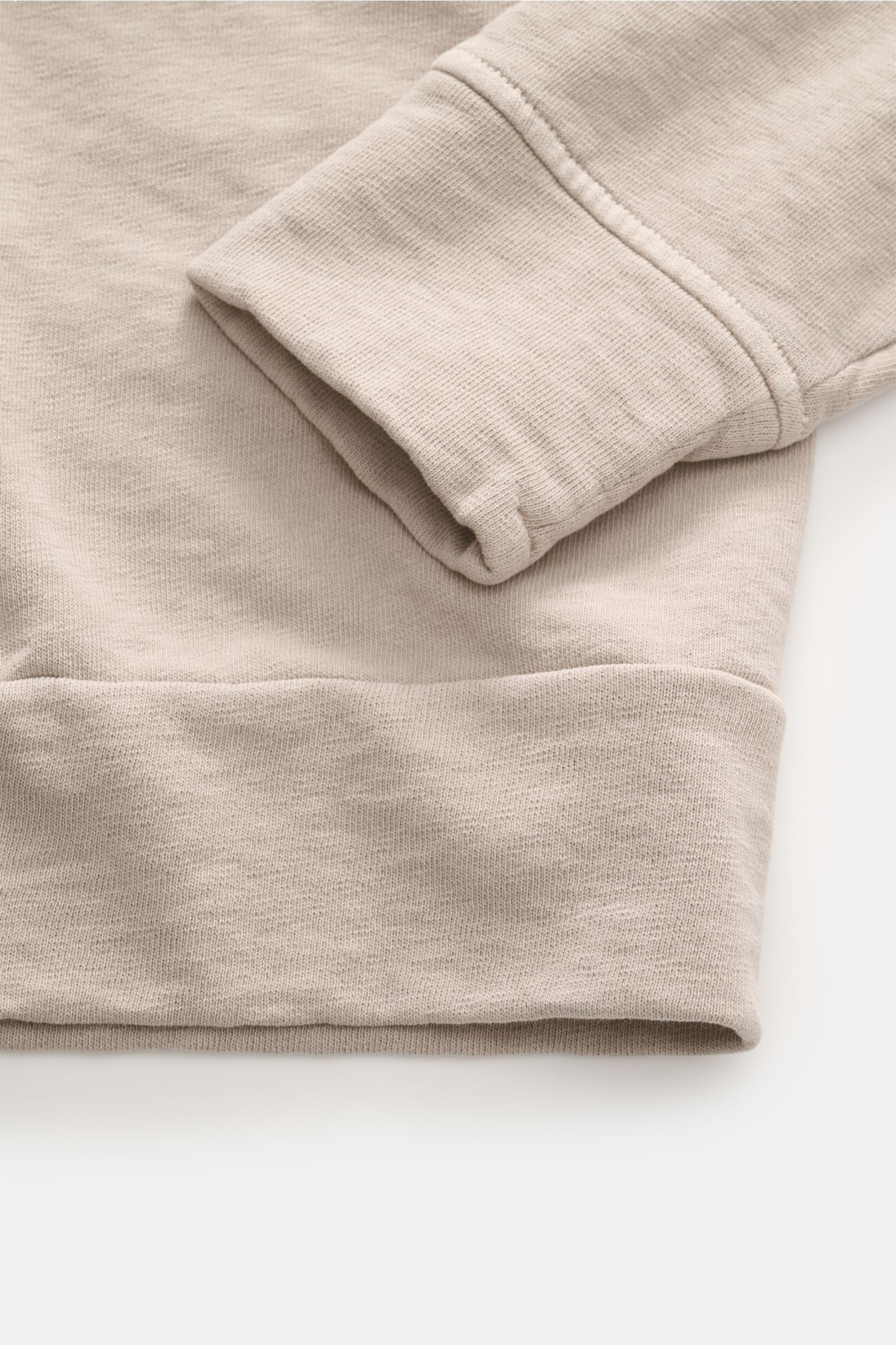 Close-up front view of the cuff and hem of the C.P. Company Rundhals-Sweatshirt beige, showing soft cotton fabric, washed design, and ribbed flexible cuffs. 