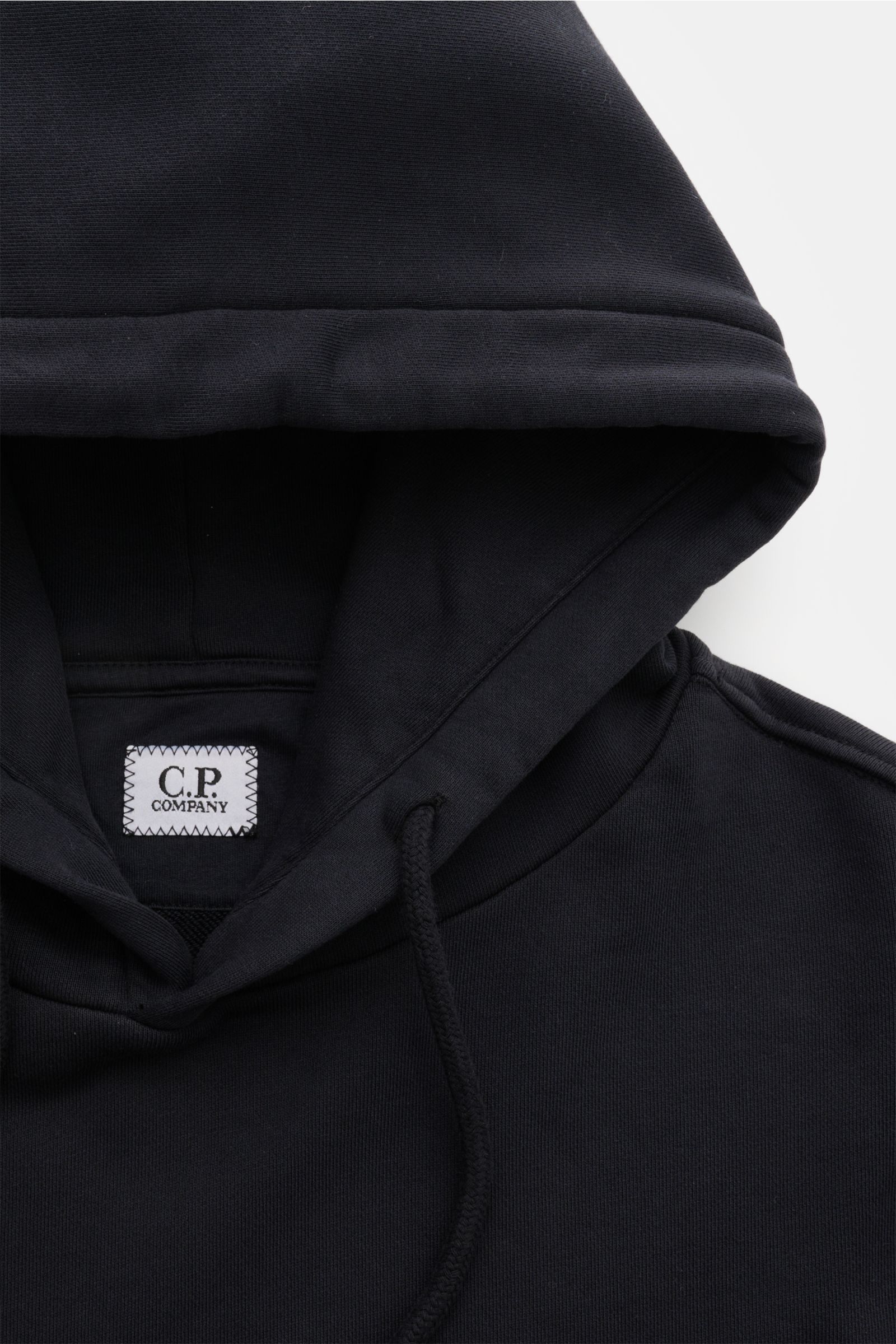 Close-up front top view of C.P. Company Hooded jumper navy in pure cotton, showing the hood with drawstring and visible brand label inside.