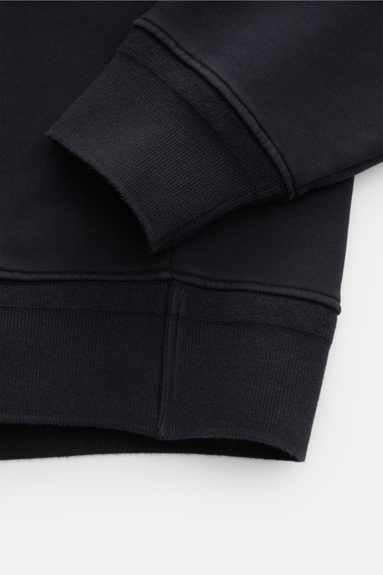 Close-up front view of the C.P. Company Hooded jumper navy showing ribbed cuff and hem in pure cotton fabric with flexible bands.