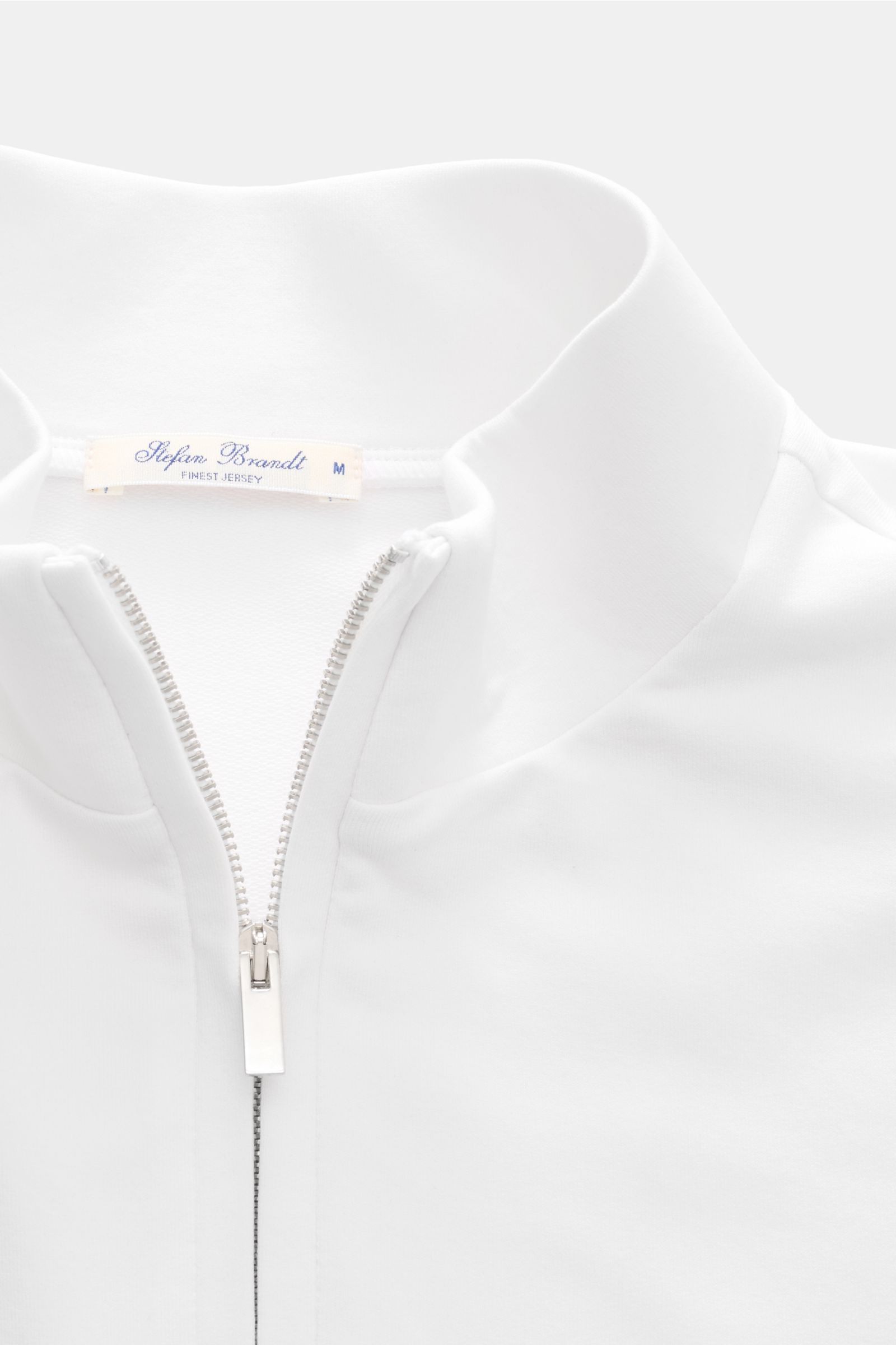 Close-up front view of the Stefan Brandt Sweat-Troyer 'Joar' weiß, showing the white high collar with a silver zipper and smooth fabric texture. Luxus, den man spürt: Selbst ein Basic wie der Sweat-Troyer 'Joar' wird bei 
