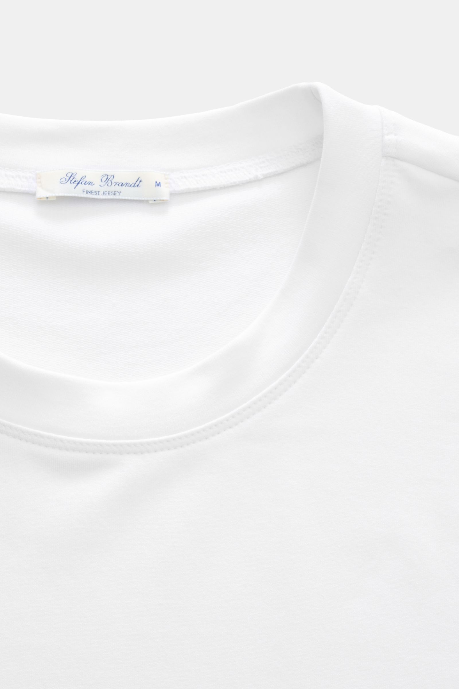 Close-up front view of the Stefan Brandt Sweatshirt 'Edwin' weiß showing the round neckline and label. Luxus, den man spürt: Selbst ein Basic wie das Sweatshirt 'Edwin' wird bei STEFAN BRANDT zum Inbegriff von Komfort und Qualität. Gefertigt aus leichter 