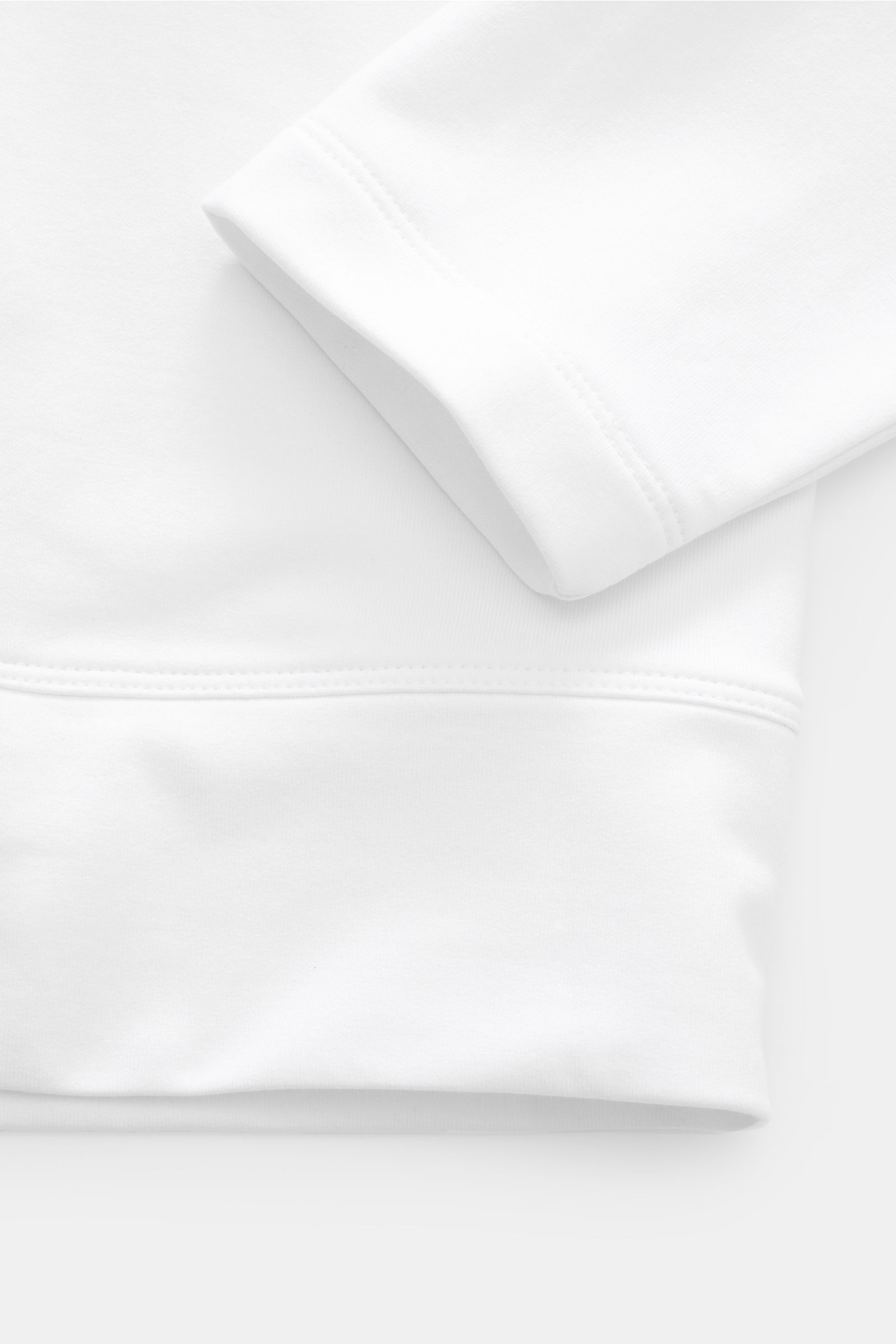 Close-up, top-down view of the cuff and hem of the Stefan Brandt Sweatshirt 'Edwin' weiß, showcasing pure Pima cotton fabric. Luxus, den man spürt: Selbst ein Basic wie das Sweatshirt 'Edwin' wird bei 