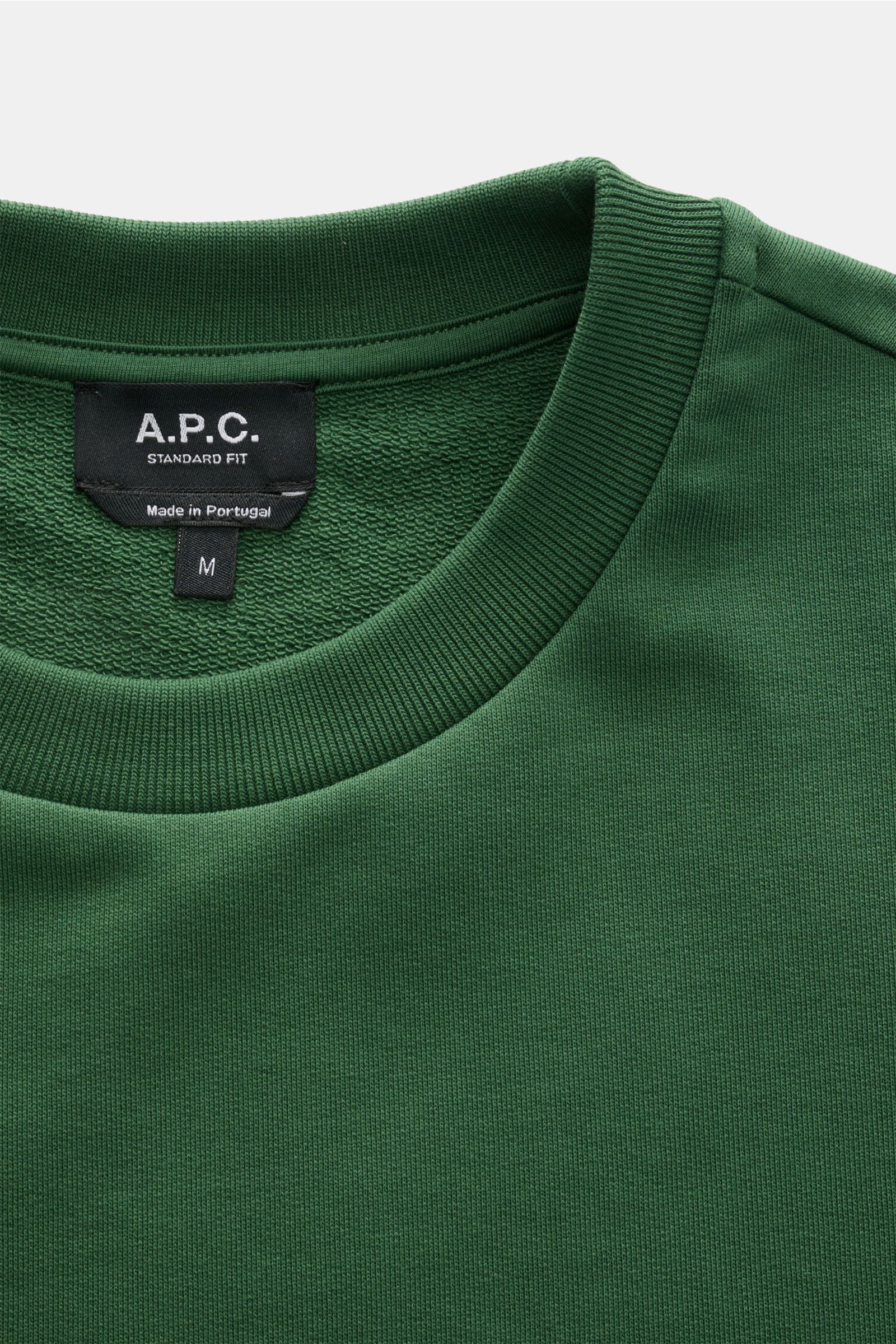 Nahaufnahme des A.P.C. Rundhals-Sweatshirt 'Standard Rue Madame' dunkelgrün mit elastischem Baumwollstoff, weichem Griff und Rippbündchen, von oben fotografiert.