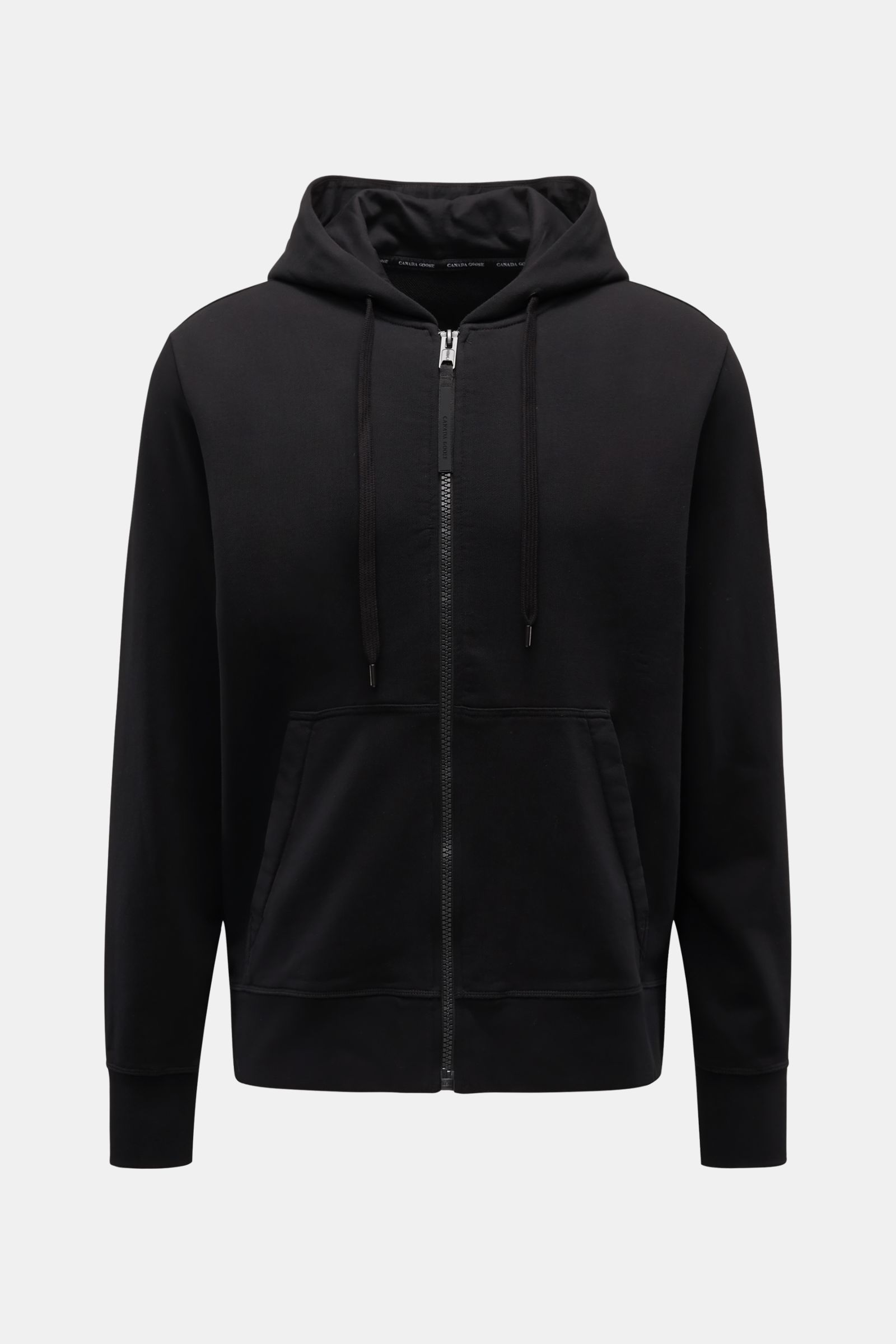 Front view of Canada Goose Sweatjacke 'Huron' schwarz, made of pure cotton sweat, soft touch, regular fit, sturdy zipper, hood with drawstring, split kangaroo pocket, CANADA GOOSE label on upper arm, and comfortable rib cuffs.