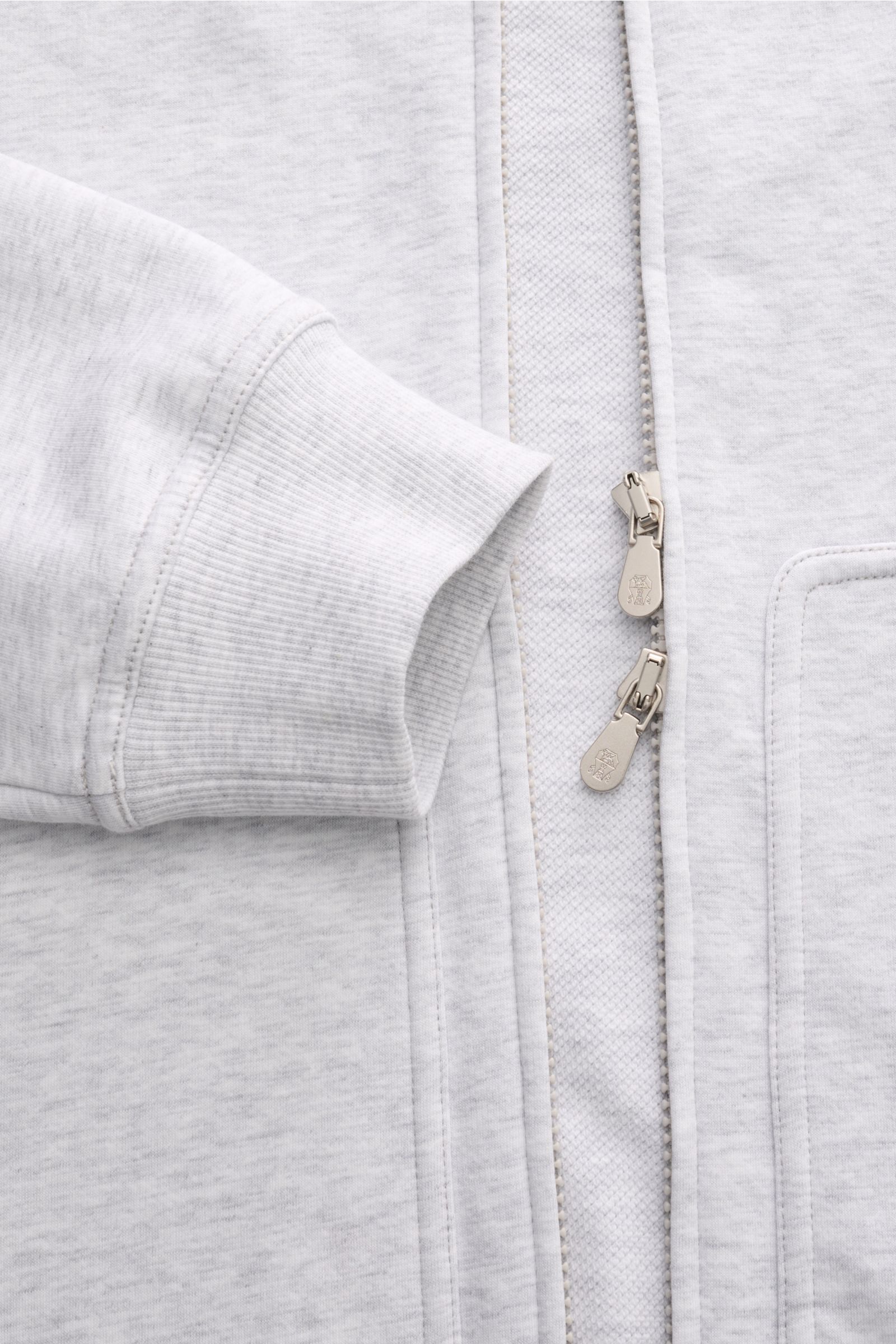 Brunello Cucinelli Sweatjacke hellgrau aus weichem Baumwolljersey mit Stretch, Regular Fit, Kapuze, verdecktem Zwei-Wege-Reißverschluss, Rippbündchen, Kängurutasche, Detailaufnahme von vorne.
