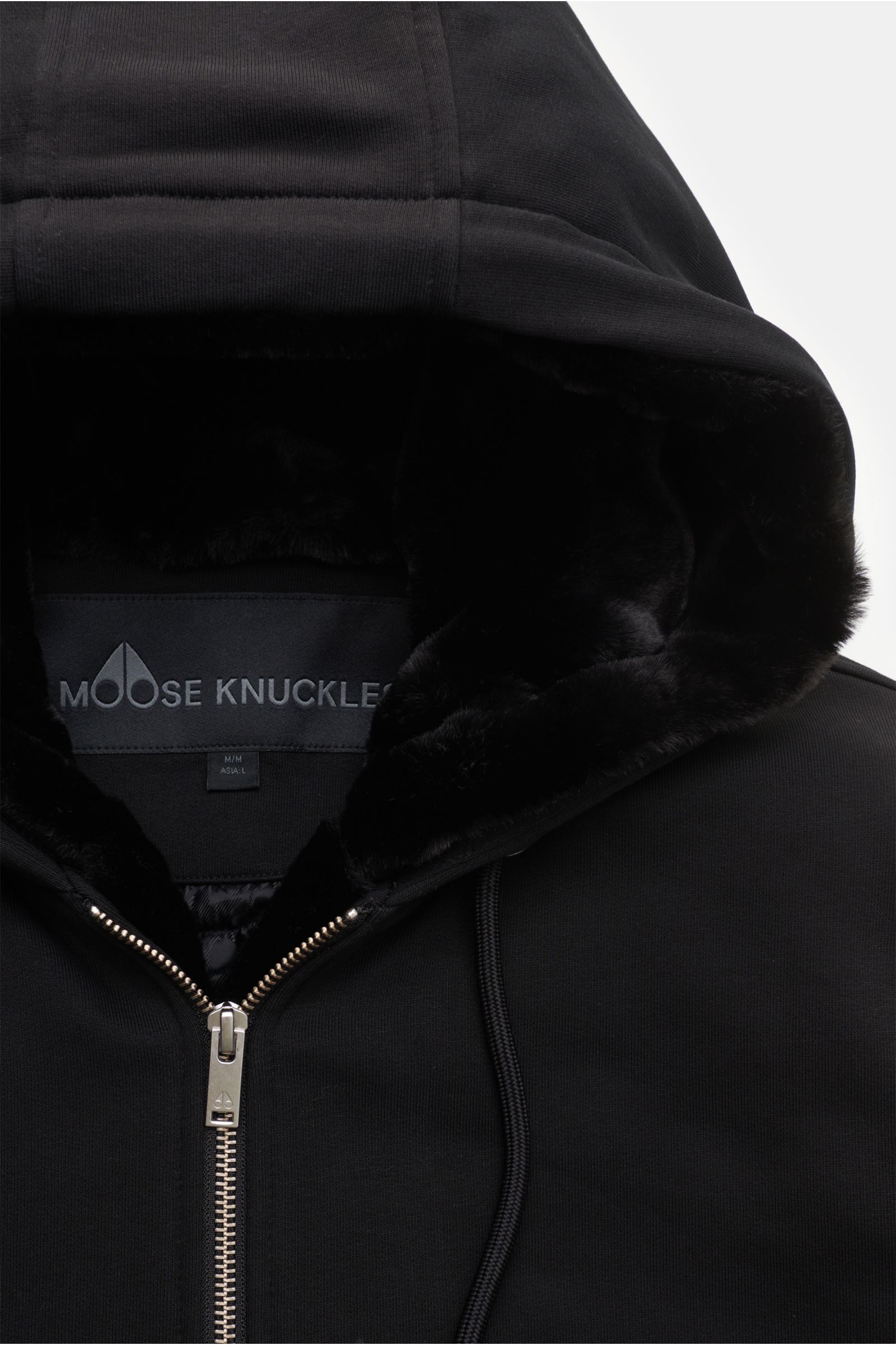 Close-up front view of the black Moose Knuckles Sweatjacke 'Classic Bunny' showing the hood with removable faux-fur lining, metal zipper, and drawstring. Perfekt für kalte Tage: Dank der leichten Wattierung und einer Kapuze mit abnehmbarem Faux-Fur-Inn