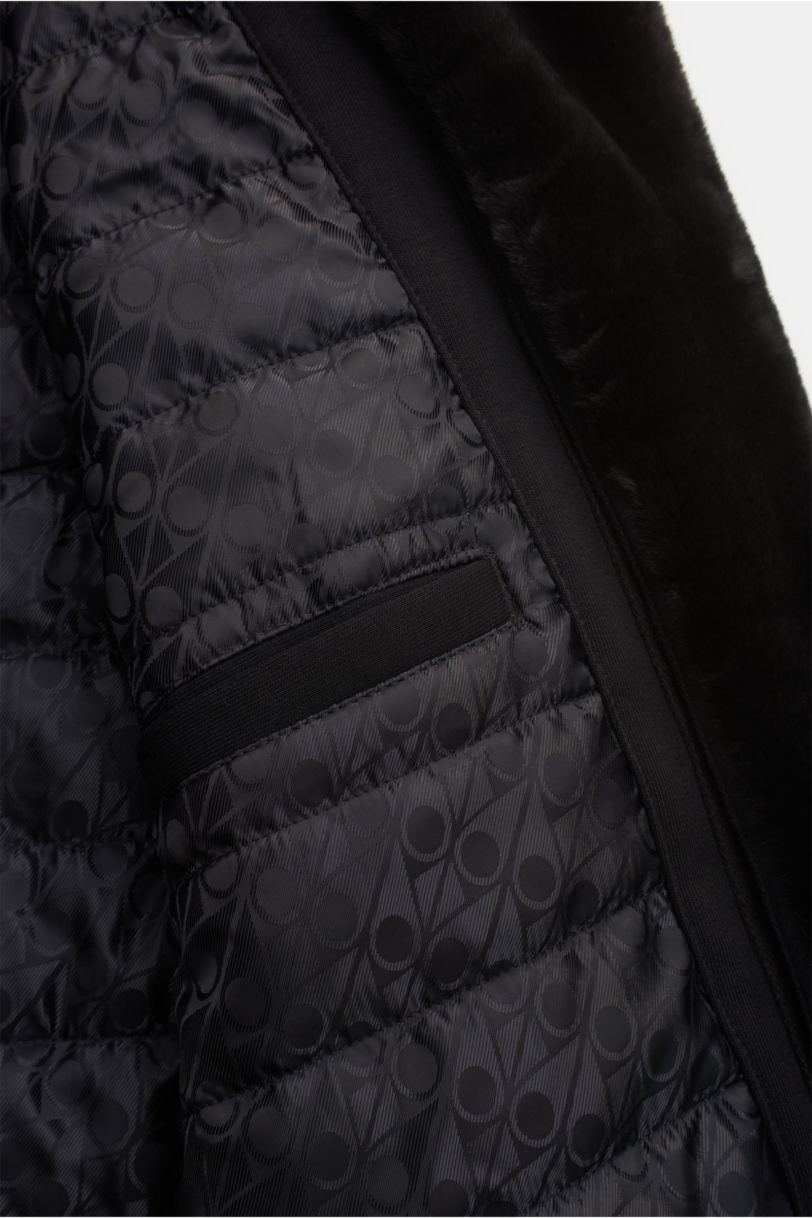 Close-up inside view of the Moose Knuckles Sweatjacke 'Classic Bunny' schwarz showing quilted patterned lining and faux-fur hood trim.

Perfekt für kalte Tage: Dank der leichten Wattierung und einer Kapuze mit abnehmbarem Faux-Fur-Innenfutter sind Sie 