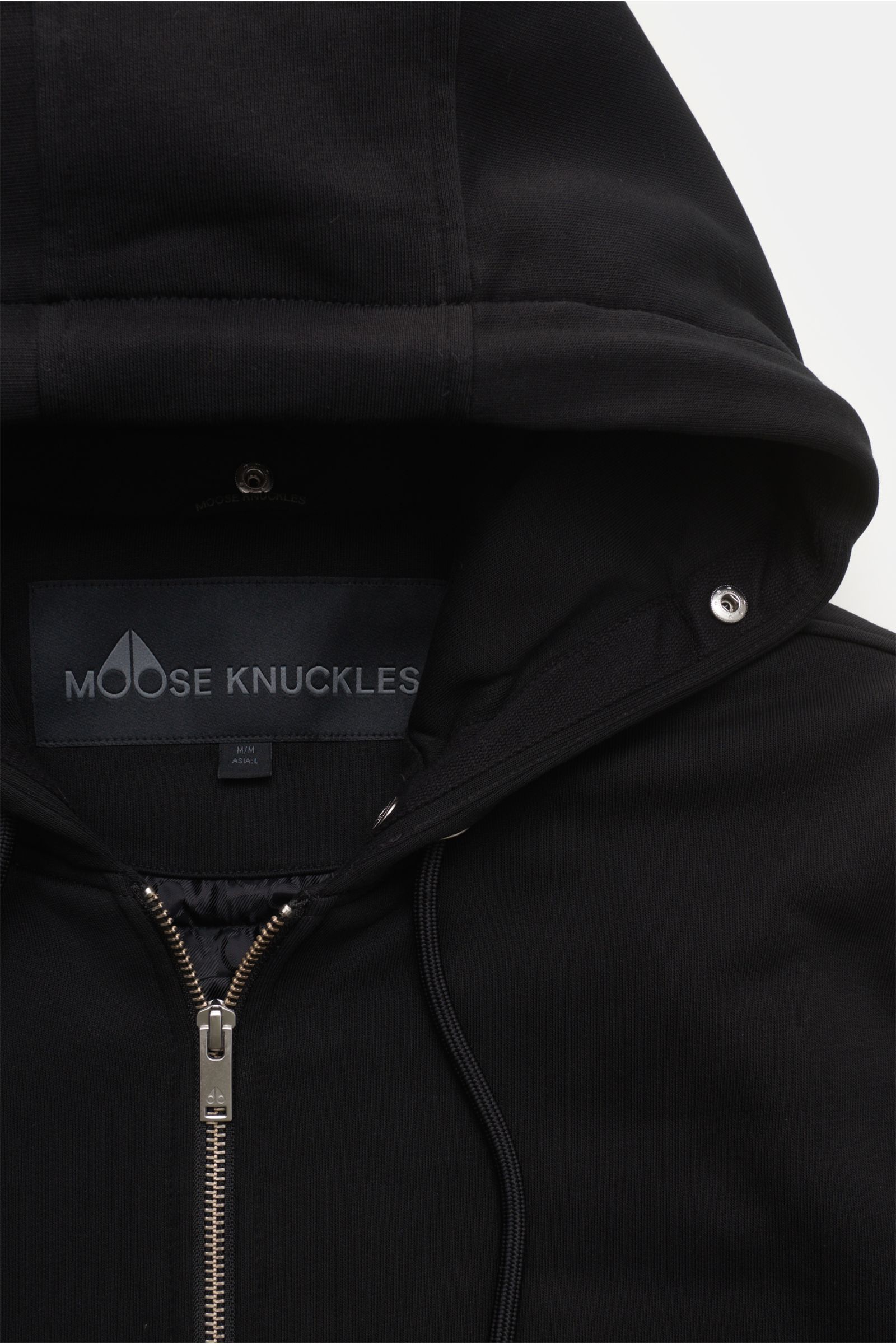 Close-up front view of Moose Knuckles Sweatjacke 'Classic Bunny' schwarz with hood, zipper, and branded label inside.

Perfekt für kalte Tage: Dank der leichten Wattierung und einer Kapuze mit abnehmbarem Faux-Fur-Innenfutter sind Sie mit der lässigen 