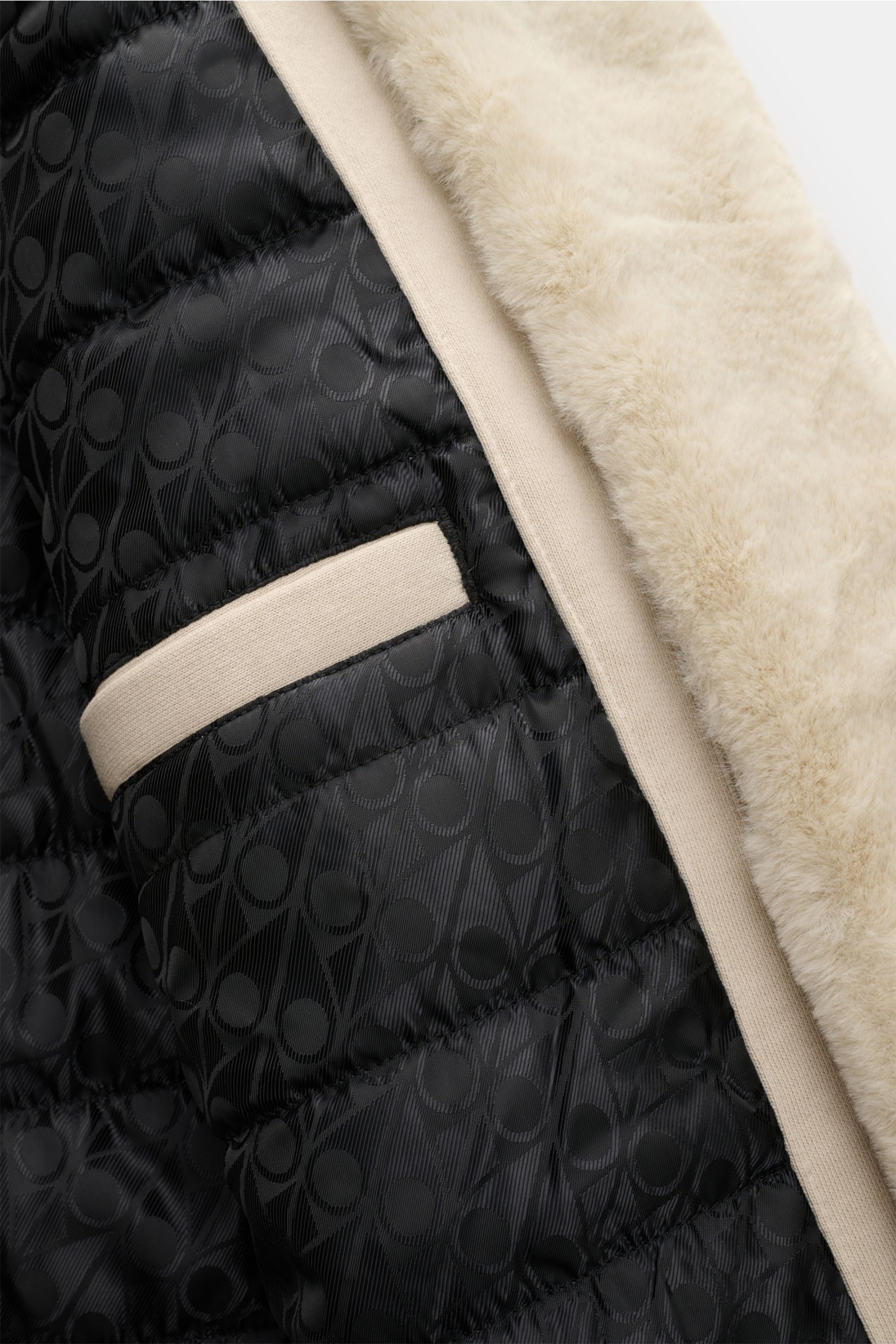 Close-up inside view of the Moose Knuckles Sweatjacke 'Classic Bunny' creme showing the soft faux-fur hood lining, quilted black branded inner fabric, and inner pocket trim. Perfekt für kalte Tage: Dank der leichten Wattierung und einer Kapuze mit abne