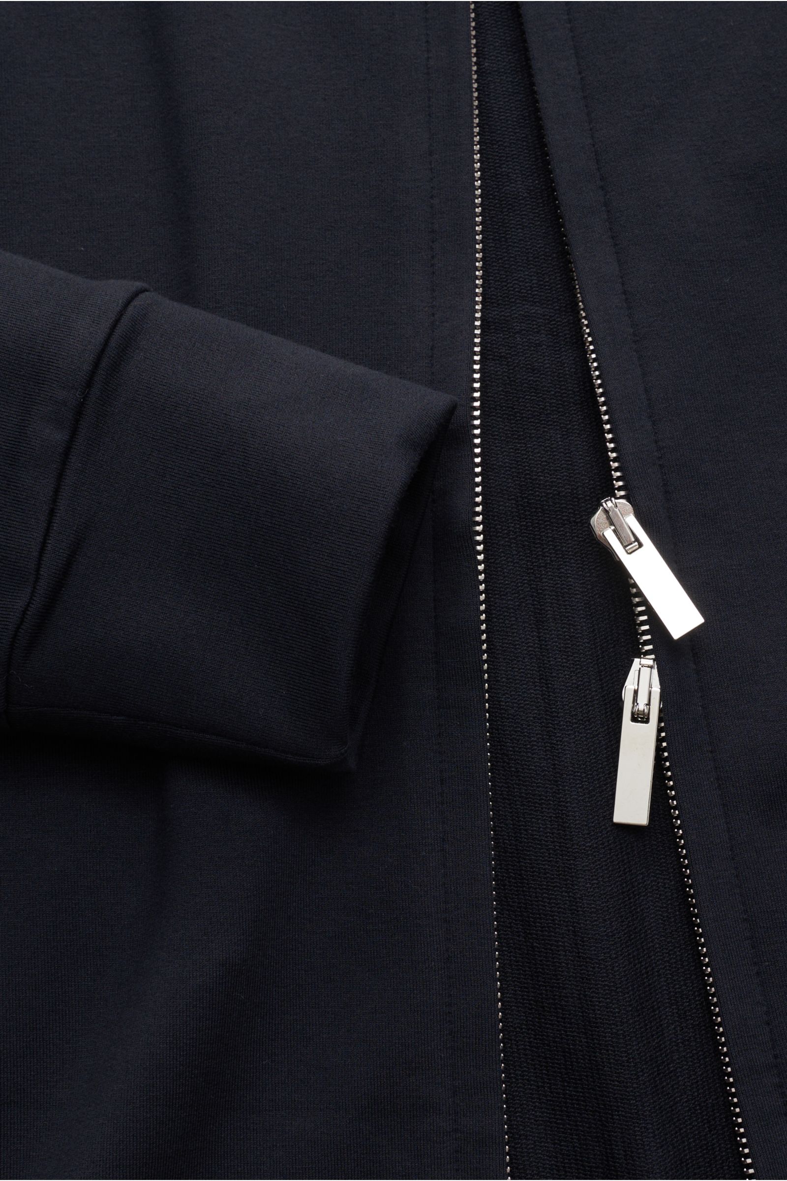 Nahaufnahme aus seitlicher Perspektive der Stefan Brandt Sweatjacke 'Joseph' dark navy mit Sweat aus reiner Pima-Baumwolle, komfortablem Stretch-Anteil, geschmeidigem Griff, leichter Qualität, Slim Fit, silberfarbenem Zwei-Wege-Reißverschluss, hoch schlie
