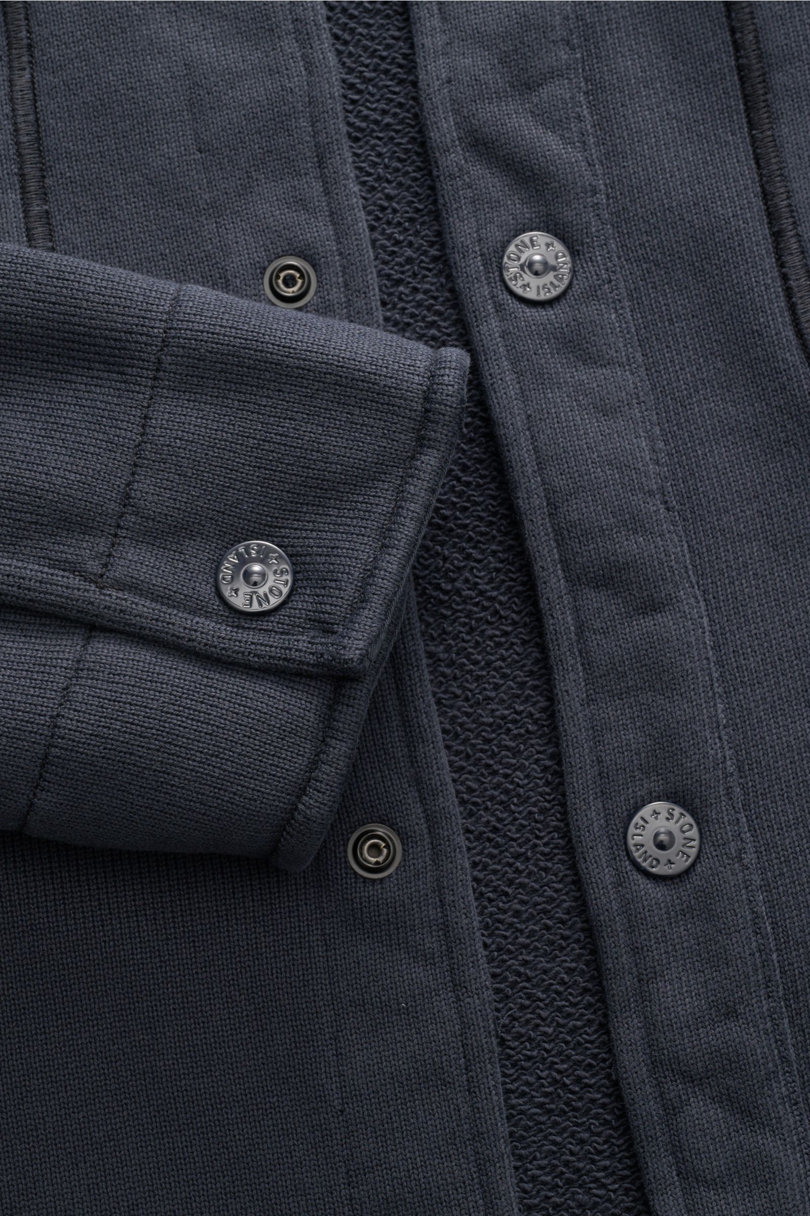 Nahaufnahme der Stone Island Sweatjacke 'Ghost' navy von schräg oben, reine Baumwolle, Regular Fit, Umlegekragen, Brusttaschen, Kompass-Badge.