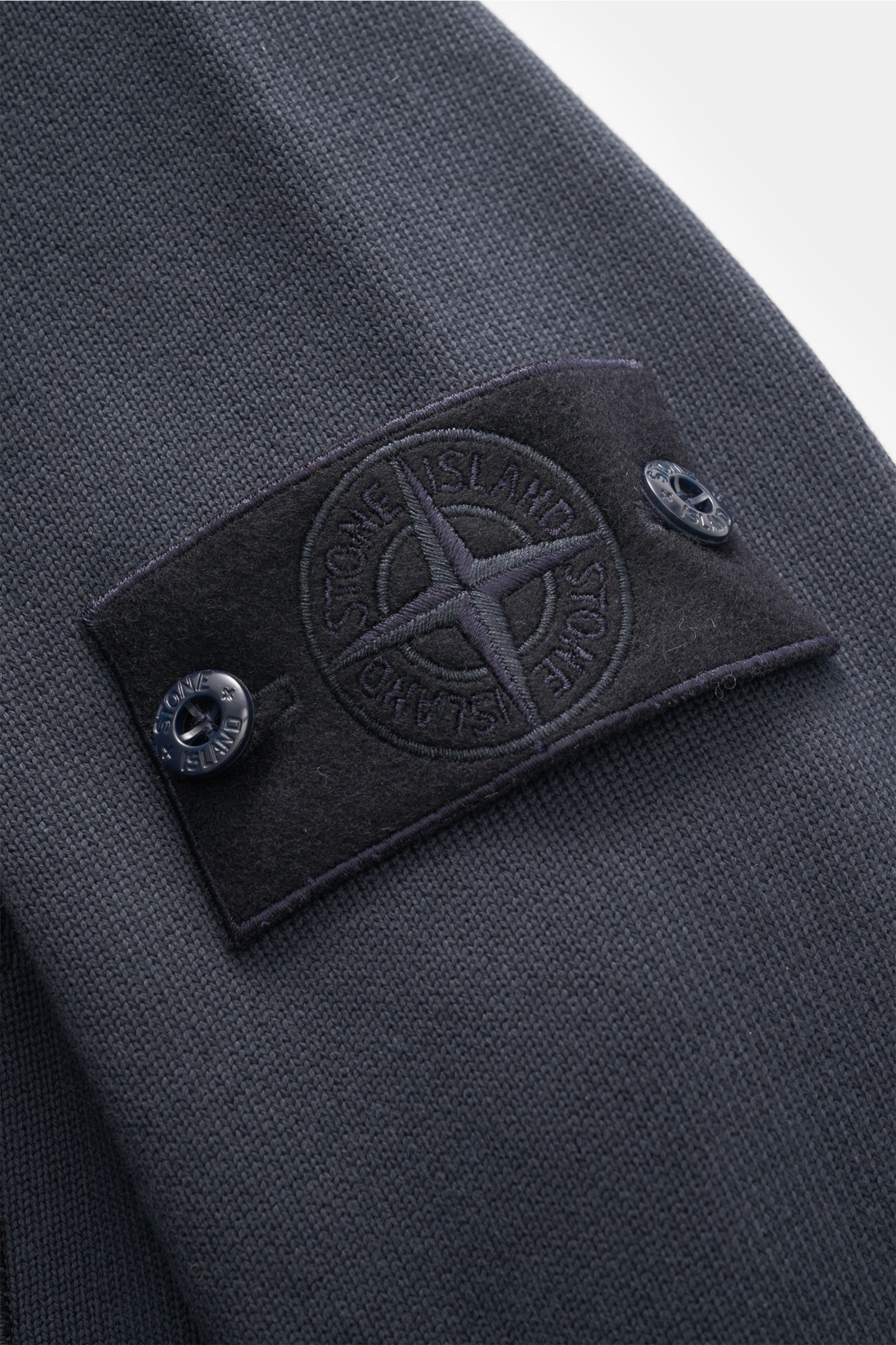 Stone Island Sweatjacke 'Ghost' navy Detailaufnahme des Kompass-Badges auf reiner Baumwolle mit mittelfeinem Strickbild, leicht griffig.