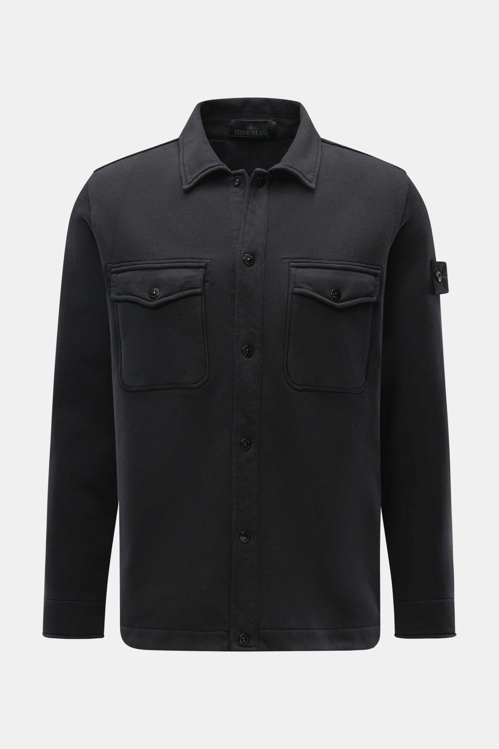 Stone Island Sweatjacke 'Ghost' schwarz, frontal fotografiert, aus reiner Baumwolle mit Regular Fit, Umlegekragen, Kompass-Badge, Brusttaschen und Manschetten.