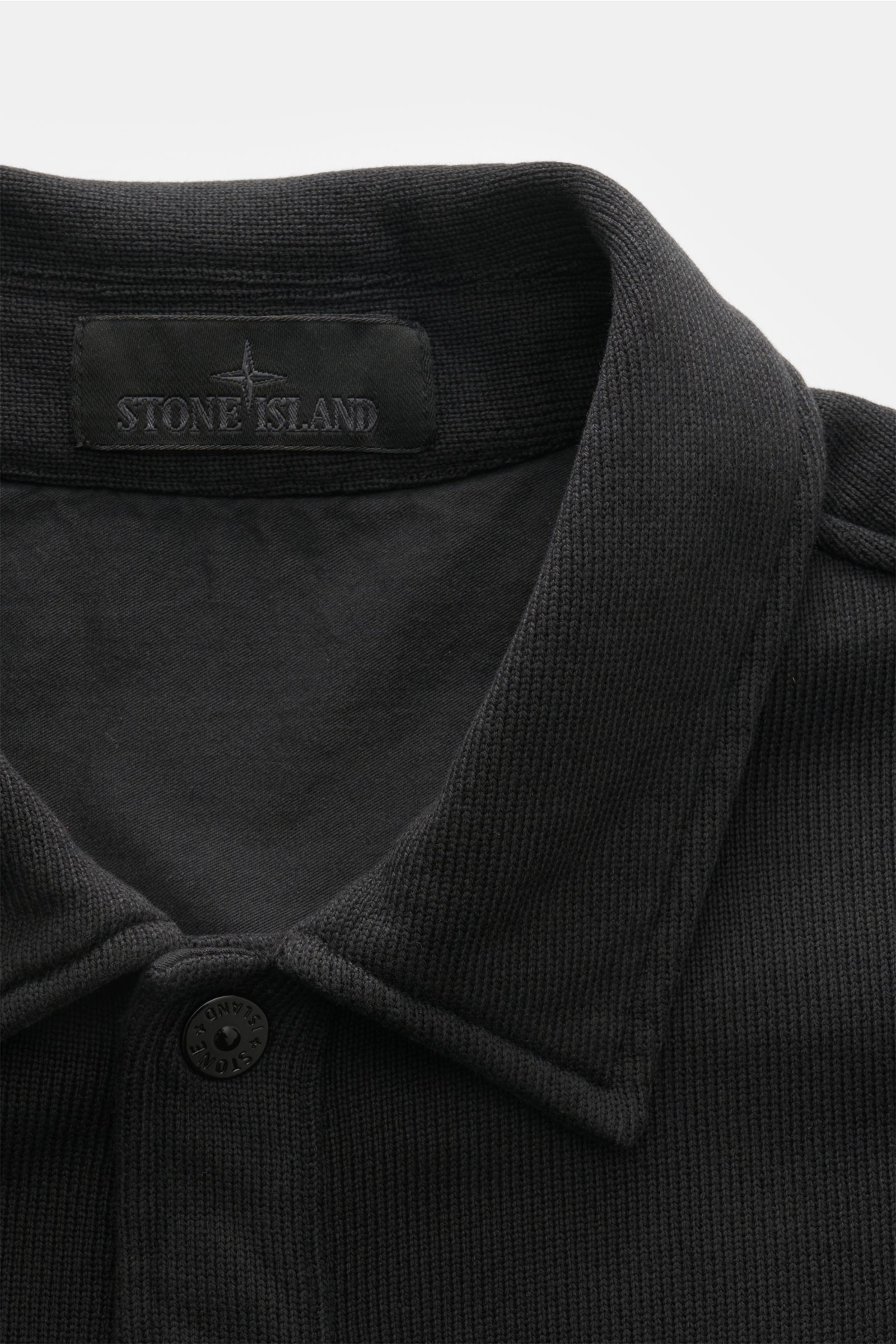 Nahaufnahme von Kragen und Knopfleiste der Stone Island Sweatjacke 'Ghost' schwarz, Regular Fit aus mittelfeinem Baumwollstrick.