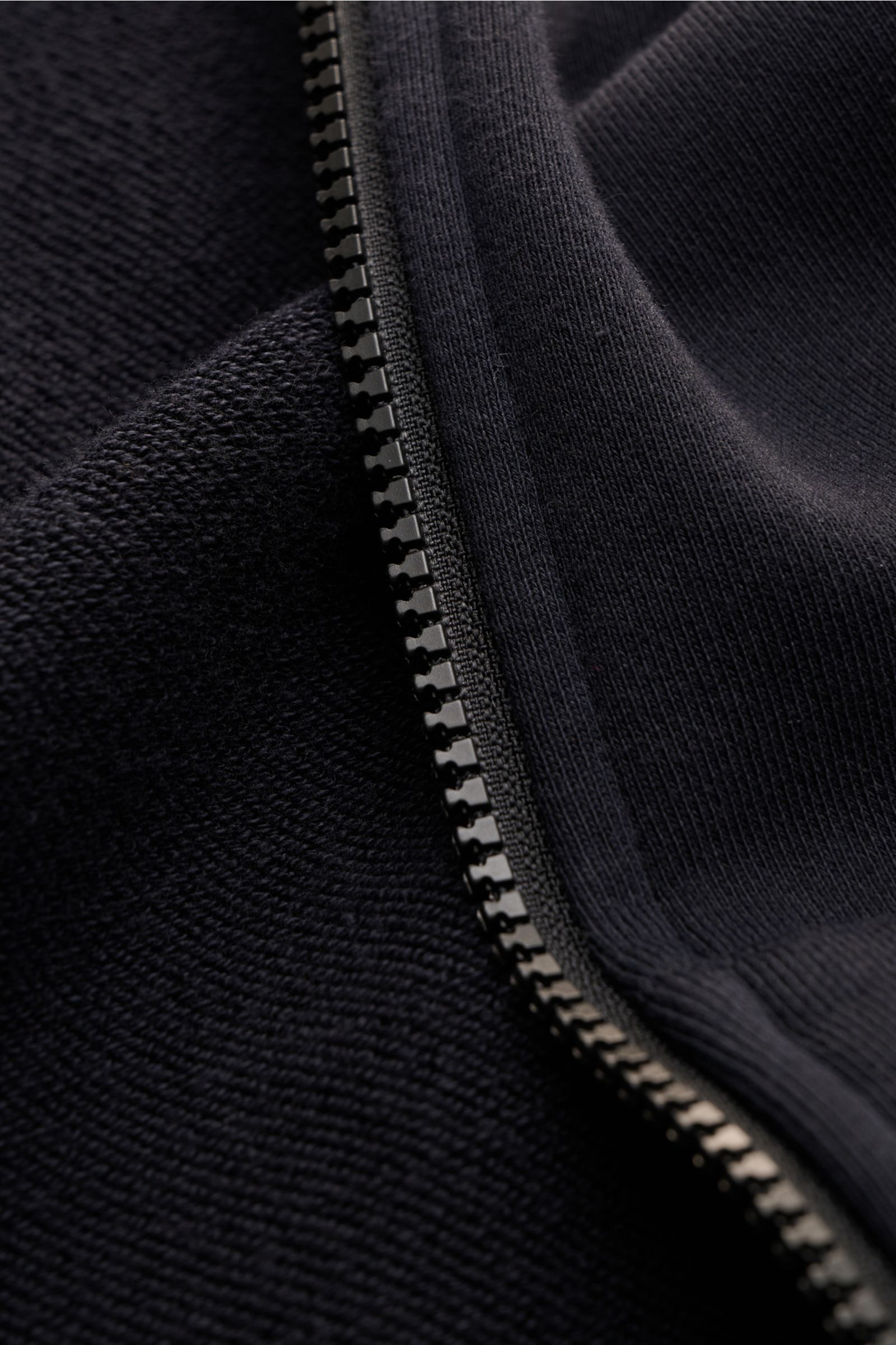 Nahaufnahme der robusten Reißverschluss- und Baumwollstruktur der Stone Island Sweatjacke dark navy, garment dyed, Regular Fit.