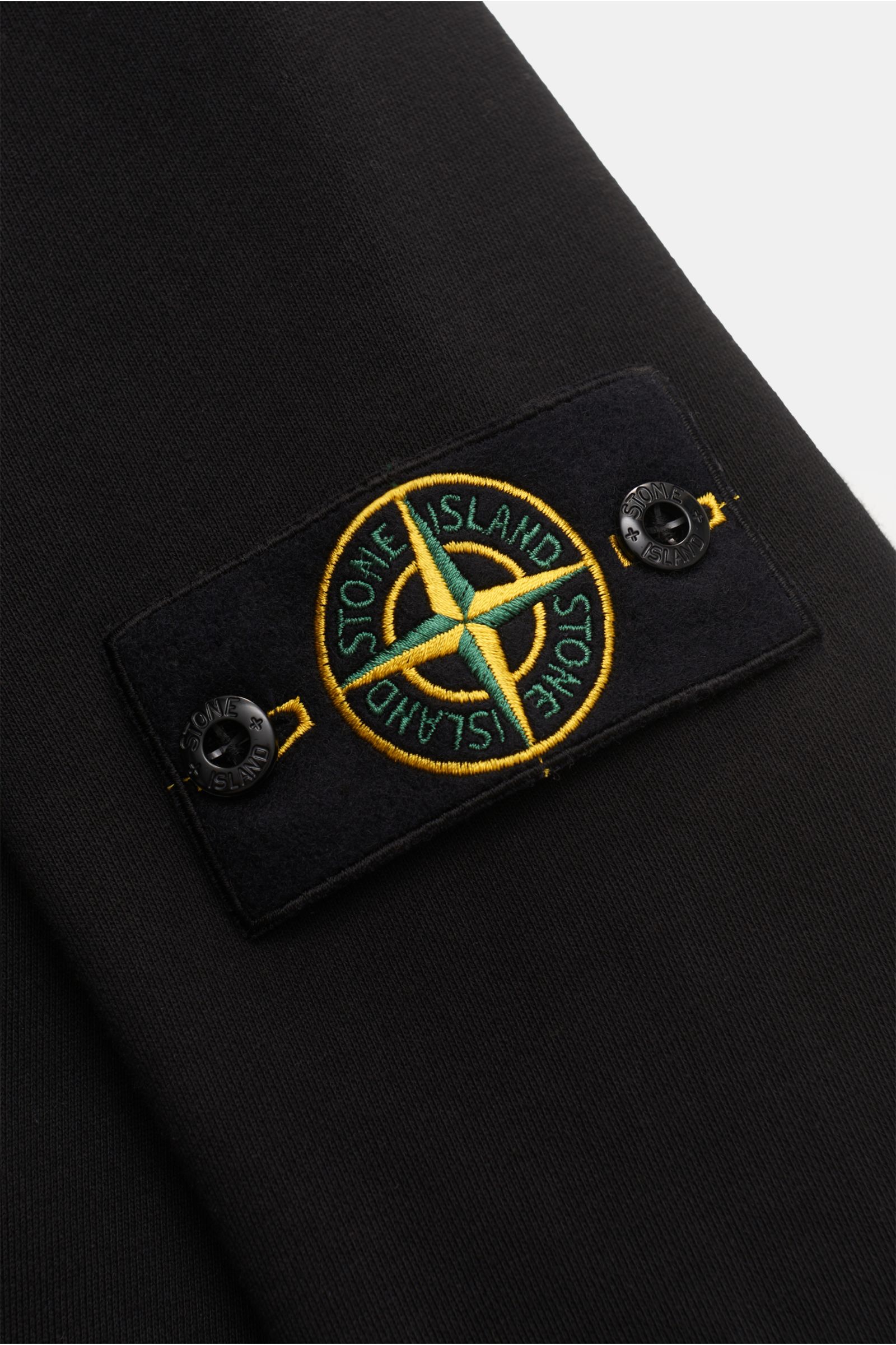 Close-up of the Stone Island Sweat jacket black showing the embroidered compass badge on black cotton fabric.

A relaxed basic from STONE ISLAND: This piece-dyed sweat jacket with a practical hood made of pure cotton is perfect for sport and leisure.
