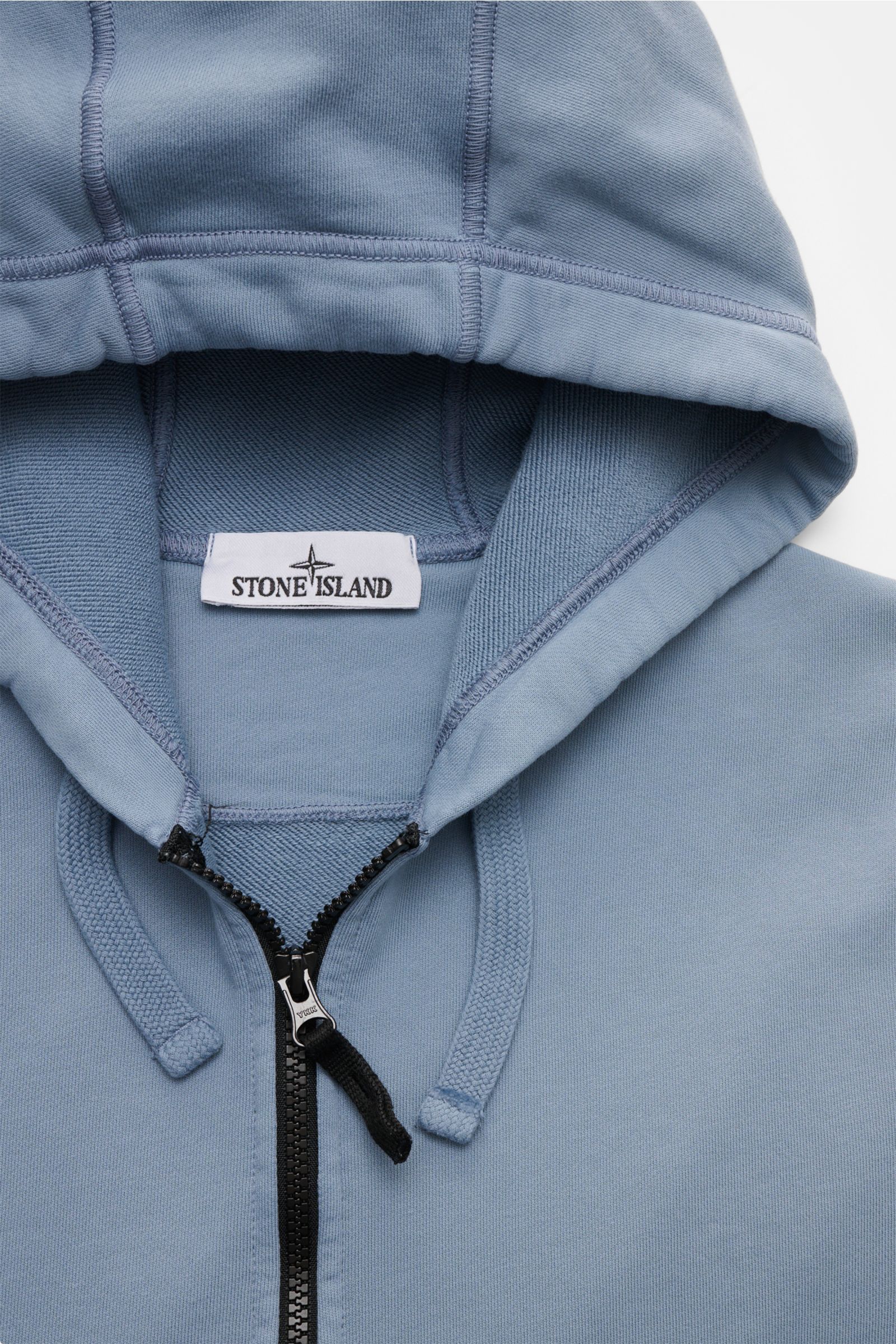 Close-up front view of Stone Island Sweat jacket smoky blue, showing the hood, drawstrings, robust black zipper, and label.

A relaxed basic from STONE ISLAND: This piece-dyed sweat jacket with a practical hood made of pure cotton is perfect for sport 