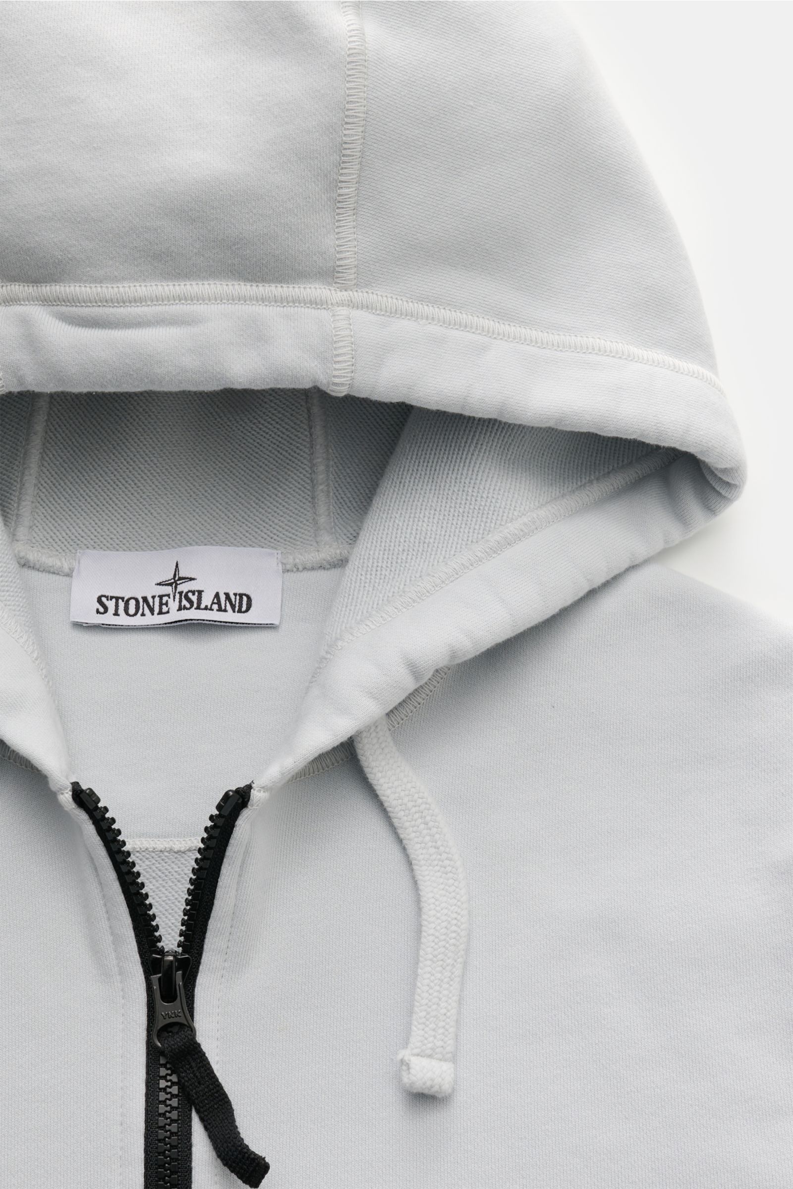 Stone Island Sweatjacke hellgrau, sportiver Regular Fit, Kapuze mit Kordel, robuster Reißverschluss, weicher Baumwoll-Sweat, Nahaufnahme von oben.
