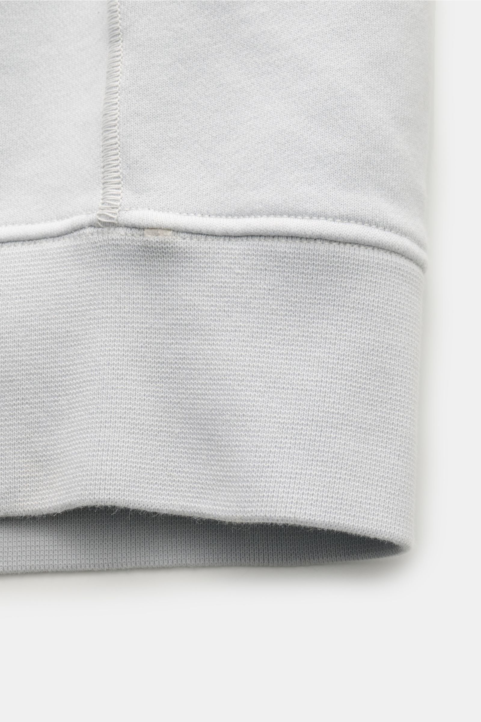 Nahaufnahme des Ärmelendes der Stone Island Sweatjacke hellgrau mit weichem Griff, Rippbündchen und feiner Baumwollstruktur.