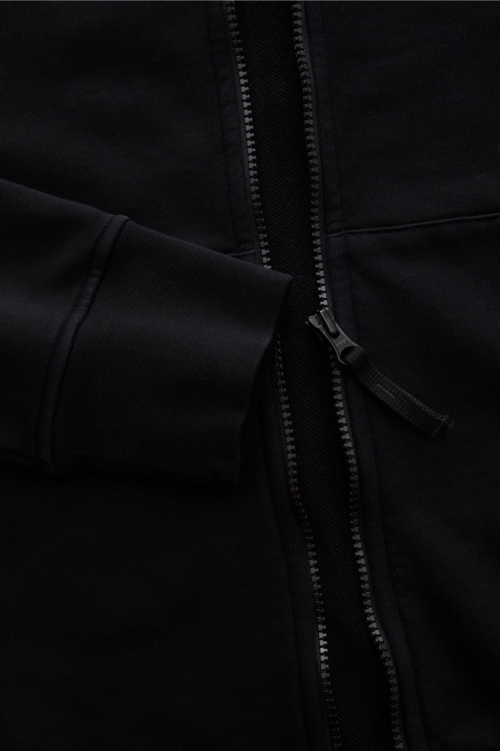 Close-up front view of the Stone Island Sweatjacke schwarz showing the robust zipper and soft ribbed cuff made from garment-dyed pure cotton.

Description: Entspanntes Basic von STONE ISLAND: Mit sportiver Lässigkeit begleitet uns die stückgefärbte Swe