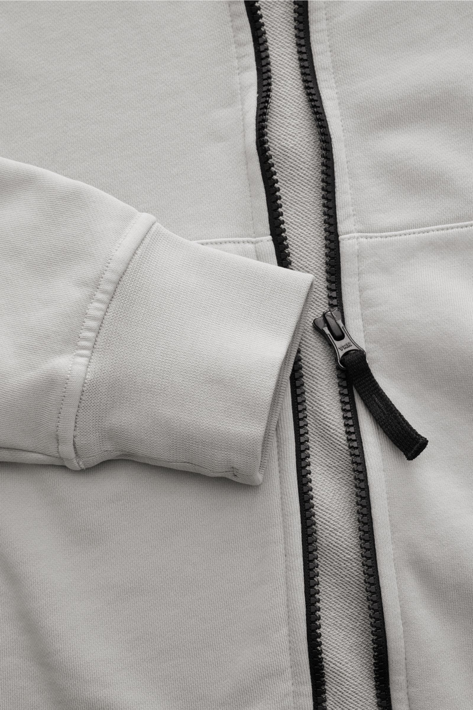 Stone Island Sweatjacke hellgrau aus weicher Baumwolle, sportiv, garment dyed, mit robustem Reißverschluss, Rippbündchen, Stehkragen, Kängurutasche, Close-up von vorne.