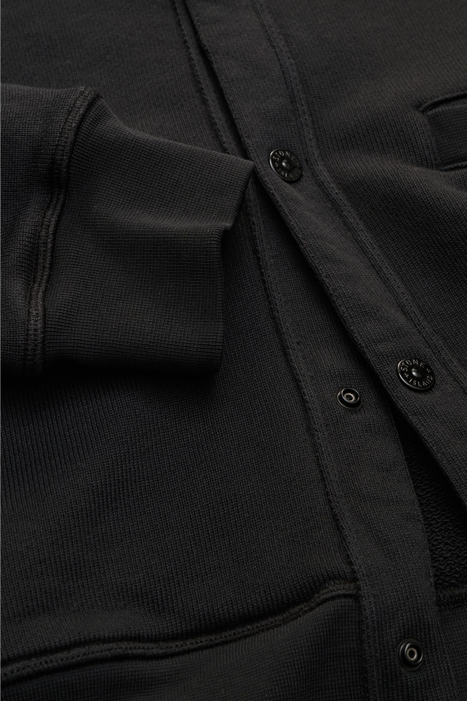 Stone Island Sweat-Cardigan 'Ghost Piece' schwarz aus reiner Baumwolle, Regular Fit, Druckknopfleiste, Leistentaschen, Kompass-Badge. Nahaufnahme frontal.
