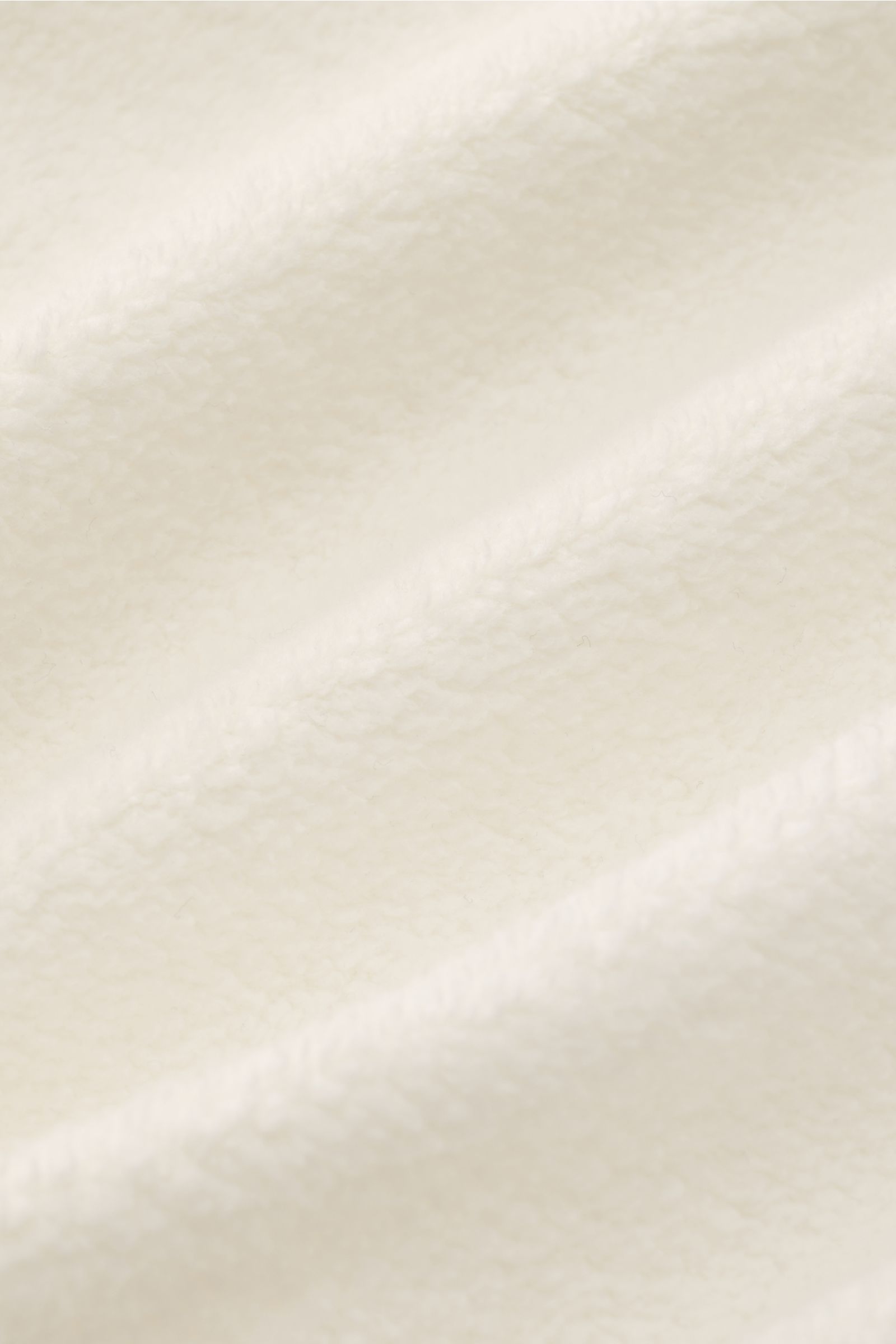 04651/ A trip in a bag Fleece-Blouson offwhite von schräg vorne, Slim Fit, Fleece aus reiner Baumwolle, weicher Griff, Druckknopfleiste, Blousonkragen, schräge Hüfttaschen, Rippbündchen, Weblabel.